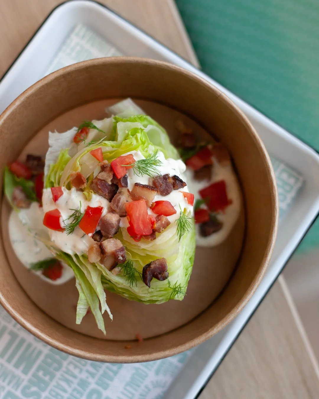 Lettuce leaf stuffed with sour cream, chopped tomatoes, diced bacon, and garnished with fresh dill.