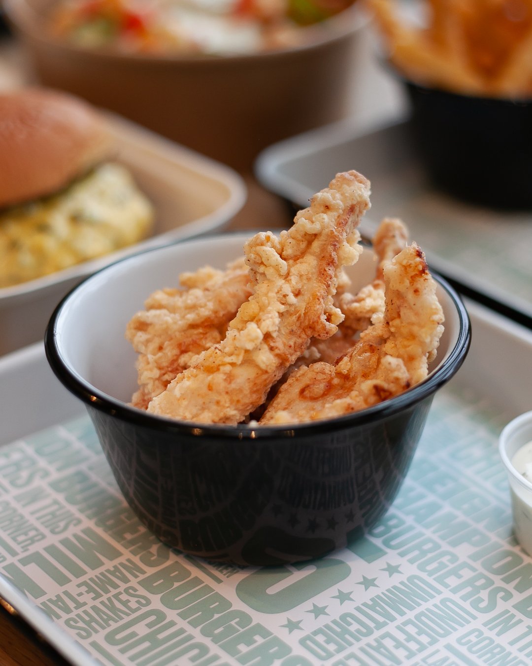Bowl of fried chicken tenders with crispy, golden coating.