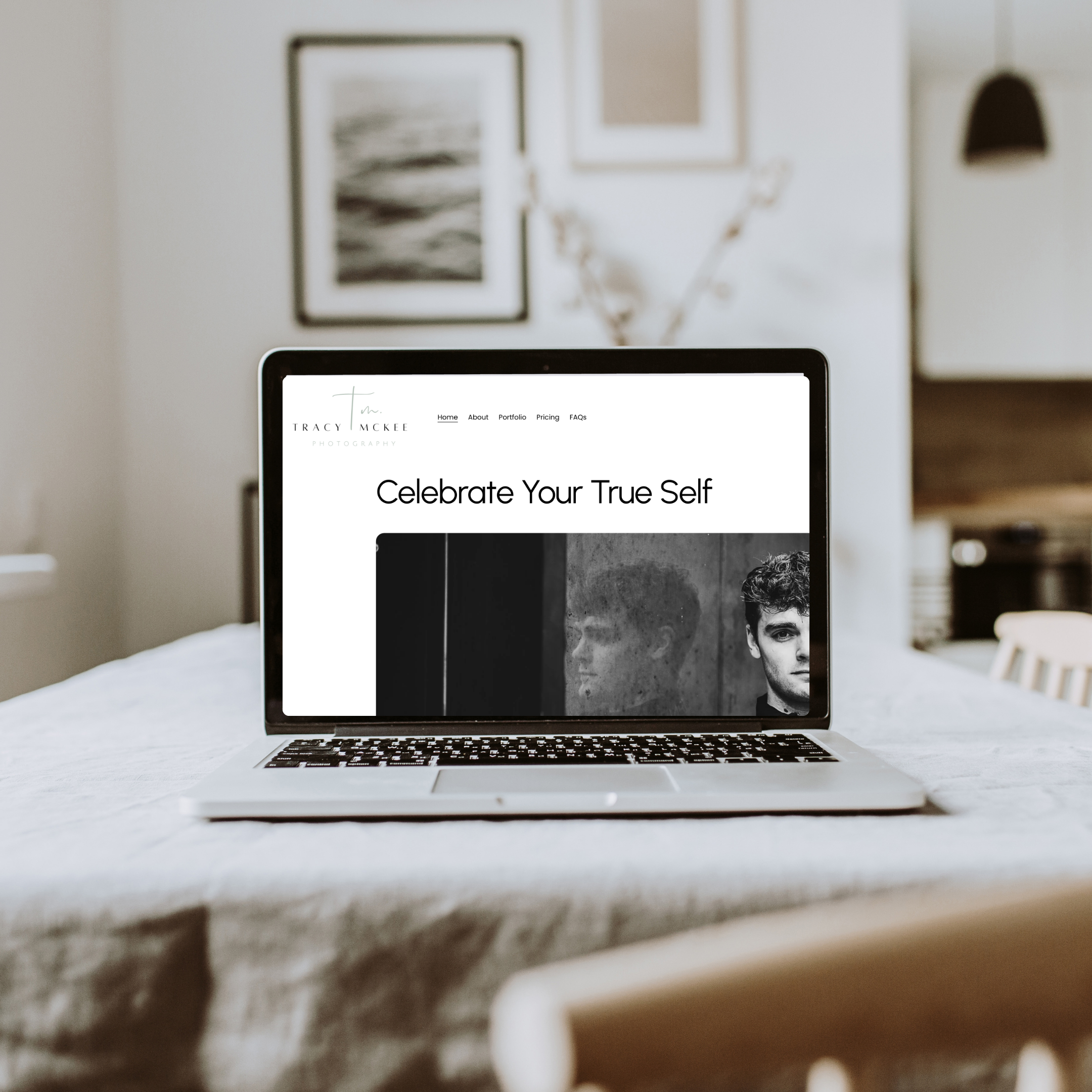 Black and white image of a woman standing, wearing a blazer, black top, ripped jeans, and high heels, smiling at the camera.