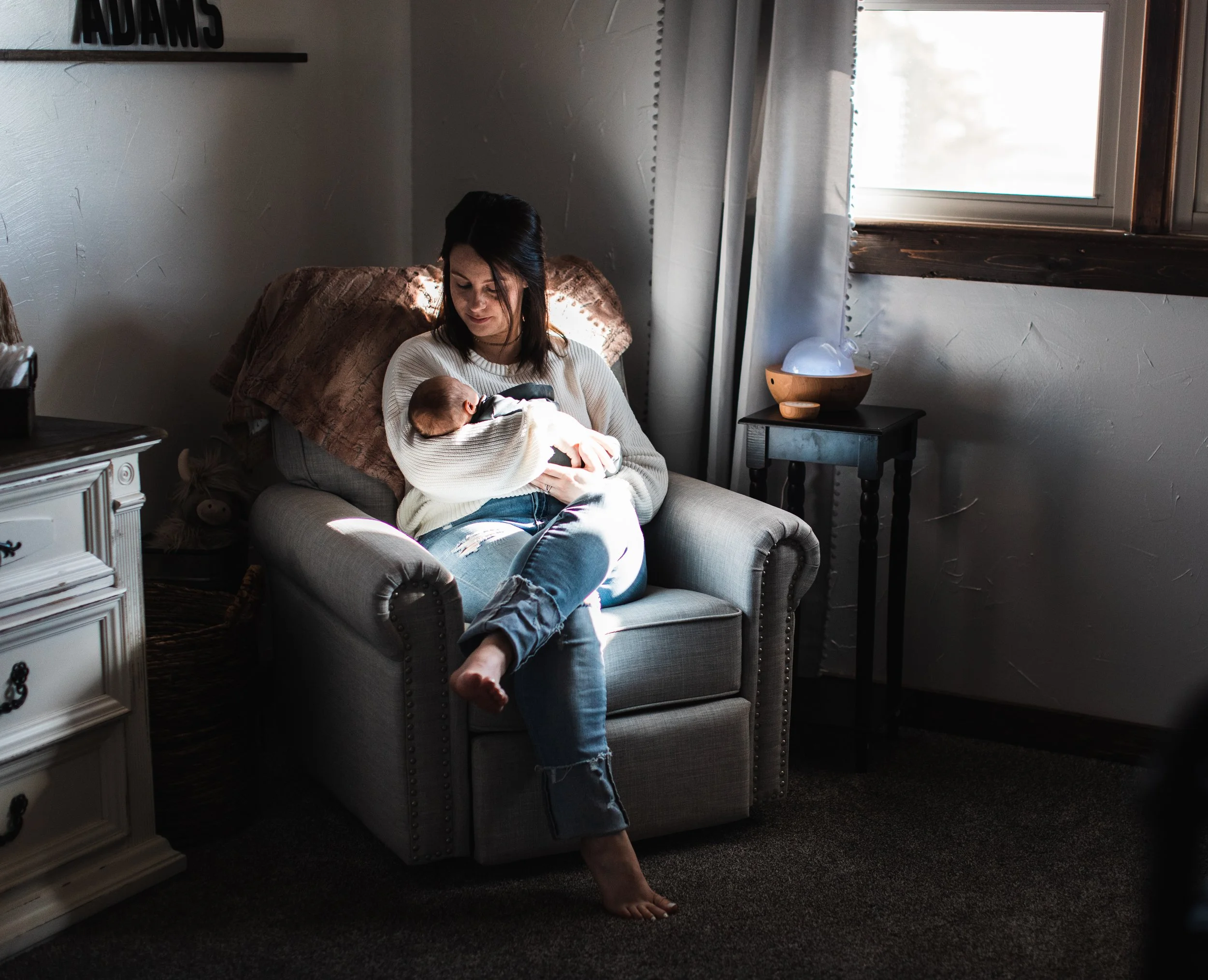 Mom holding baby in nursery