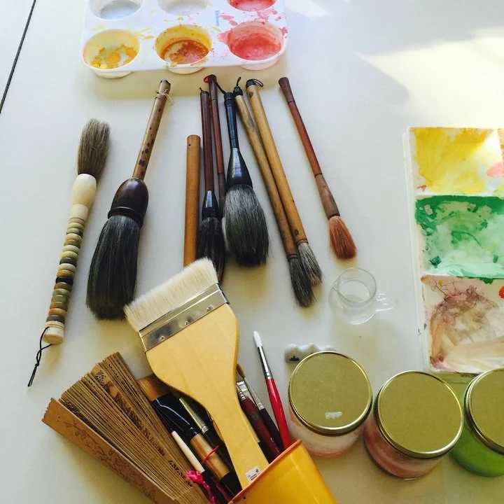 gouache and watercolor with brushes and fan used for speeding up drying of paint