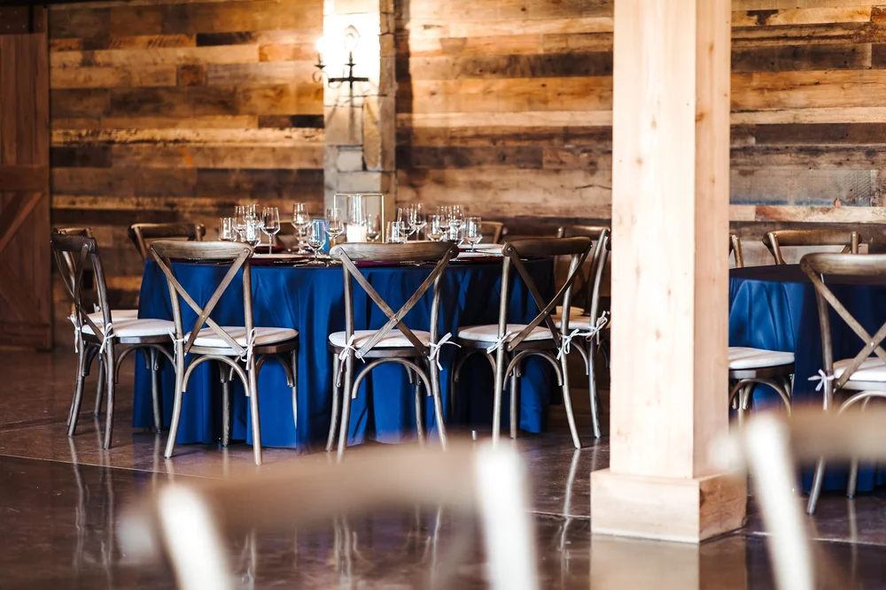 Tables set for a gathering inside The Melissa Barn