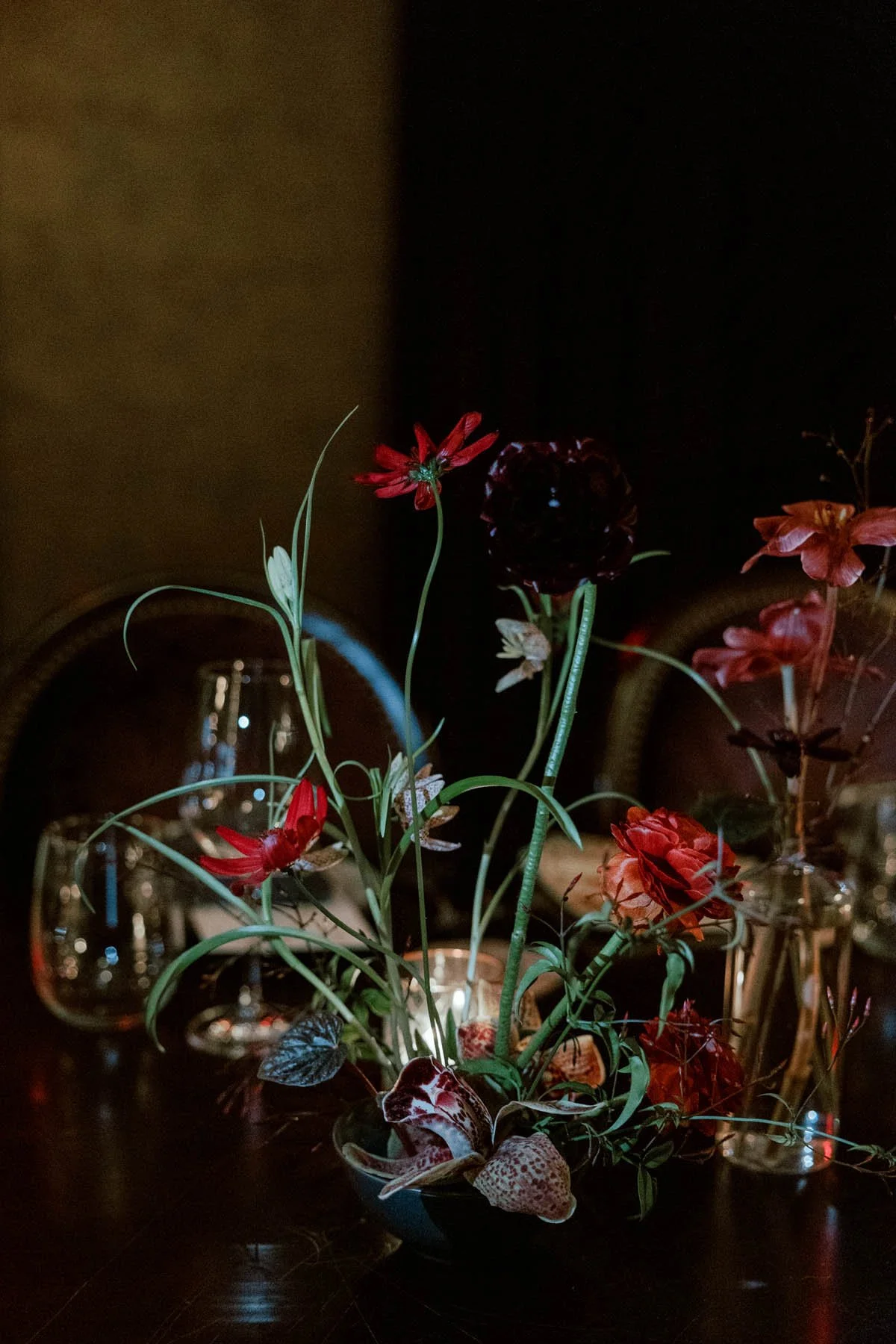 Moody Orchid and Ranunculus Centerpiece with Deep Red Accents