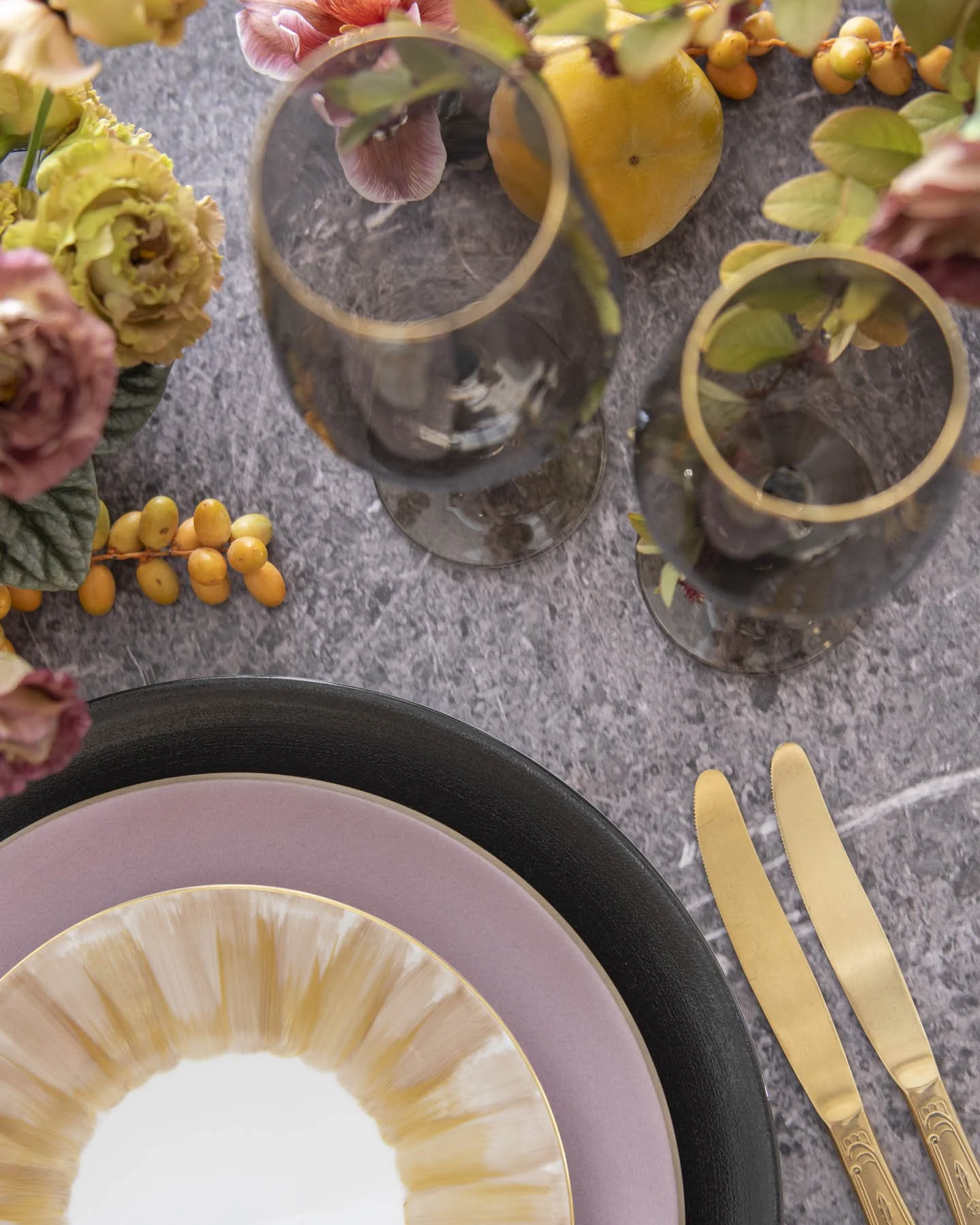 Modern Wedding Table Flat Lay with Yellow Fruit, Smoky Glassware, and Blush Plates