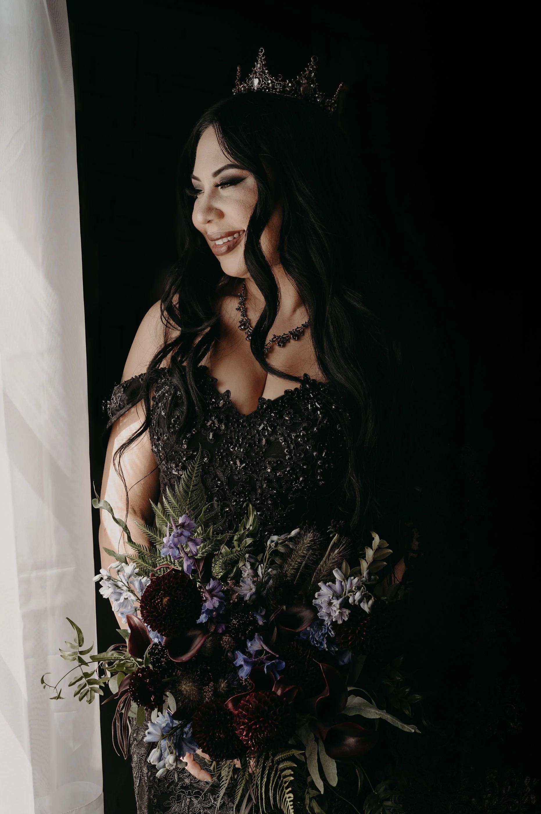 Gothic bride in a black gown with a purple burgundy bouquet