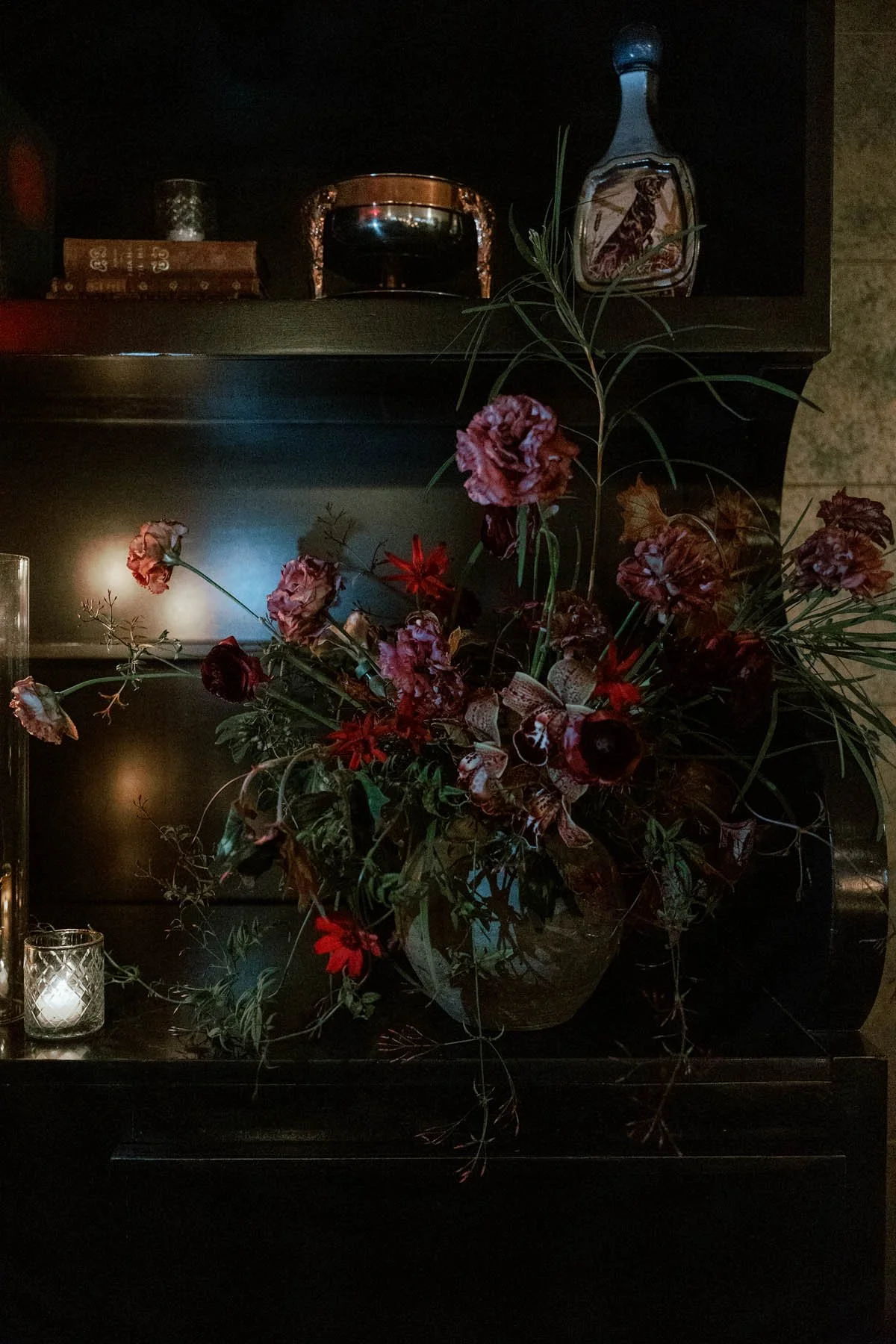 Moody Mantel Arrangement with Ruffled Carnations and Deep Crimson