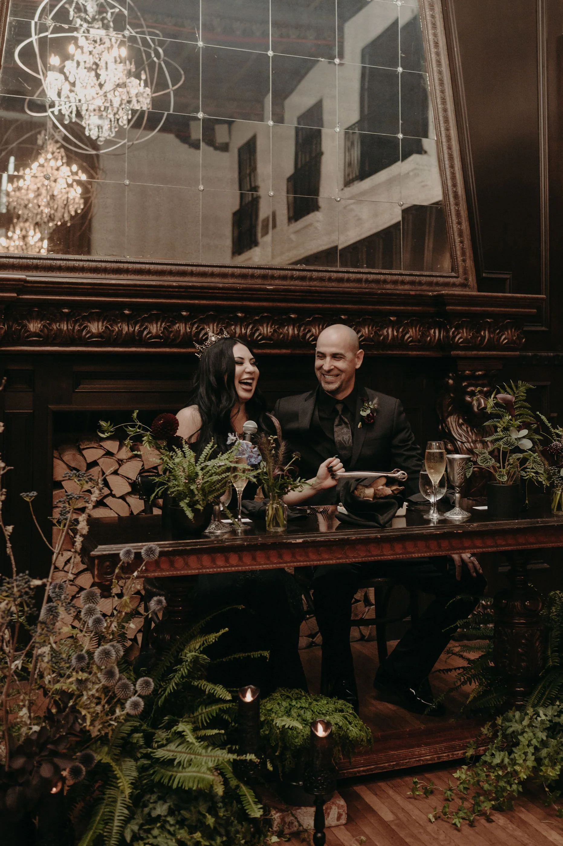 Newlyweds sitting at a gothic forest inspired sweetheart table.jpg