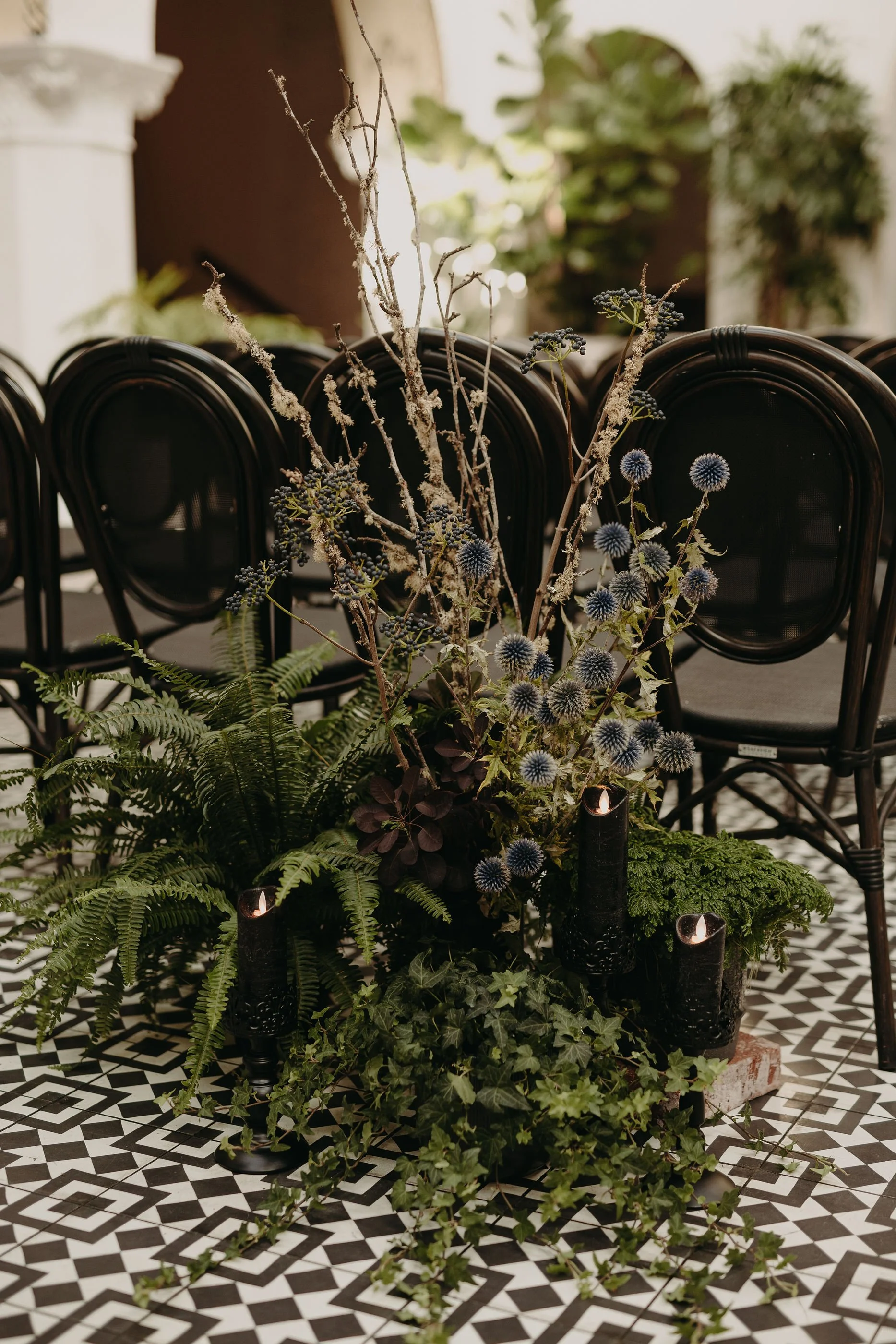 Gothic wedding ceremony aisle arrangement with ferns and branches