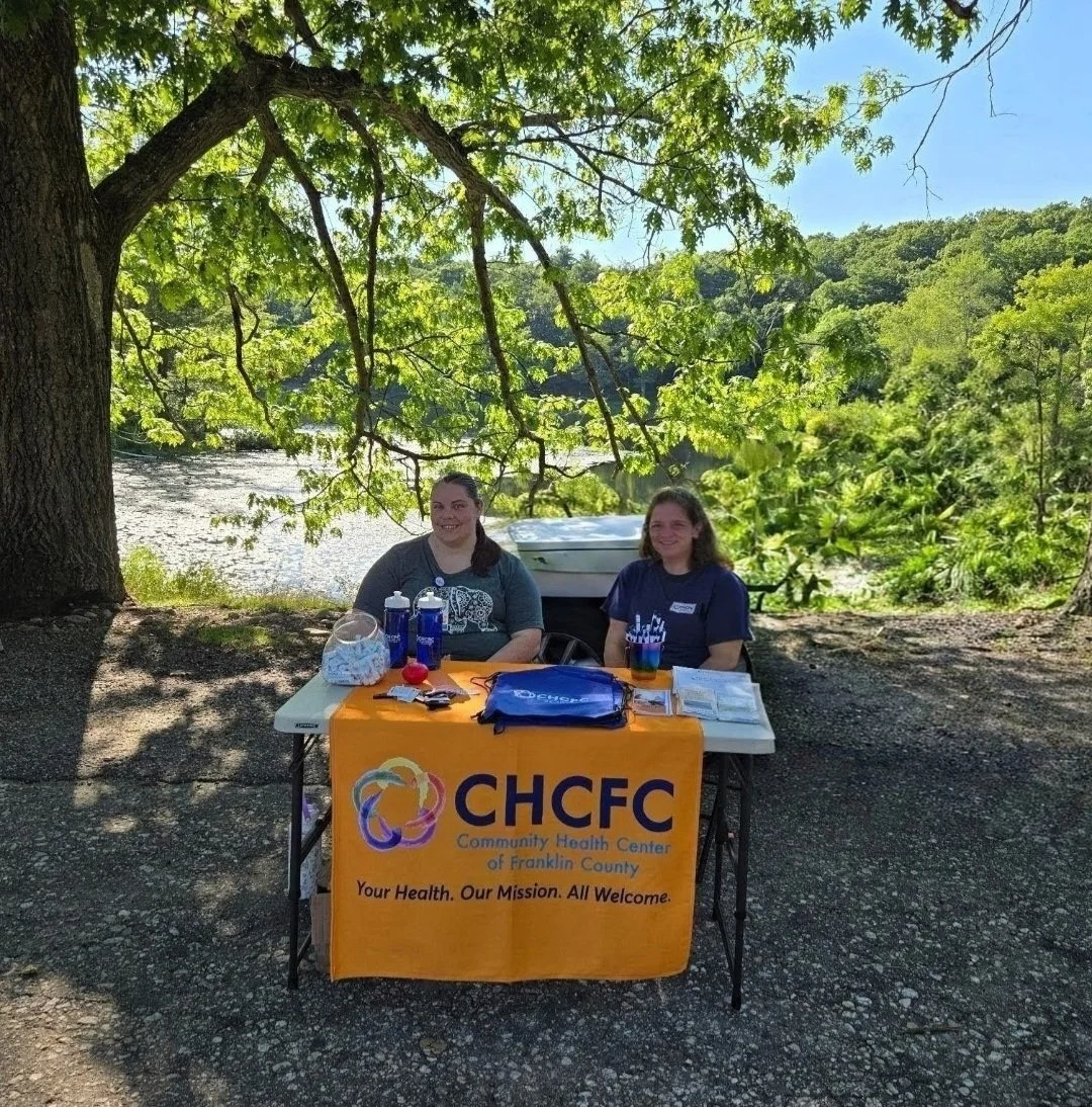 Two members of our Community Health Worker Team tabling outside.