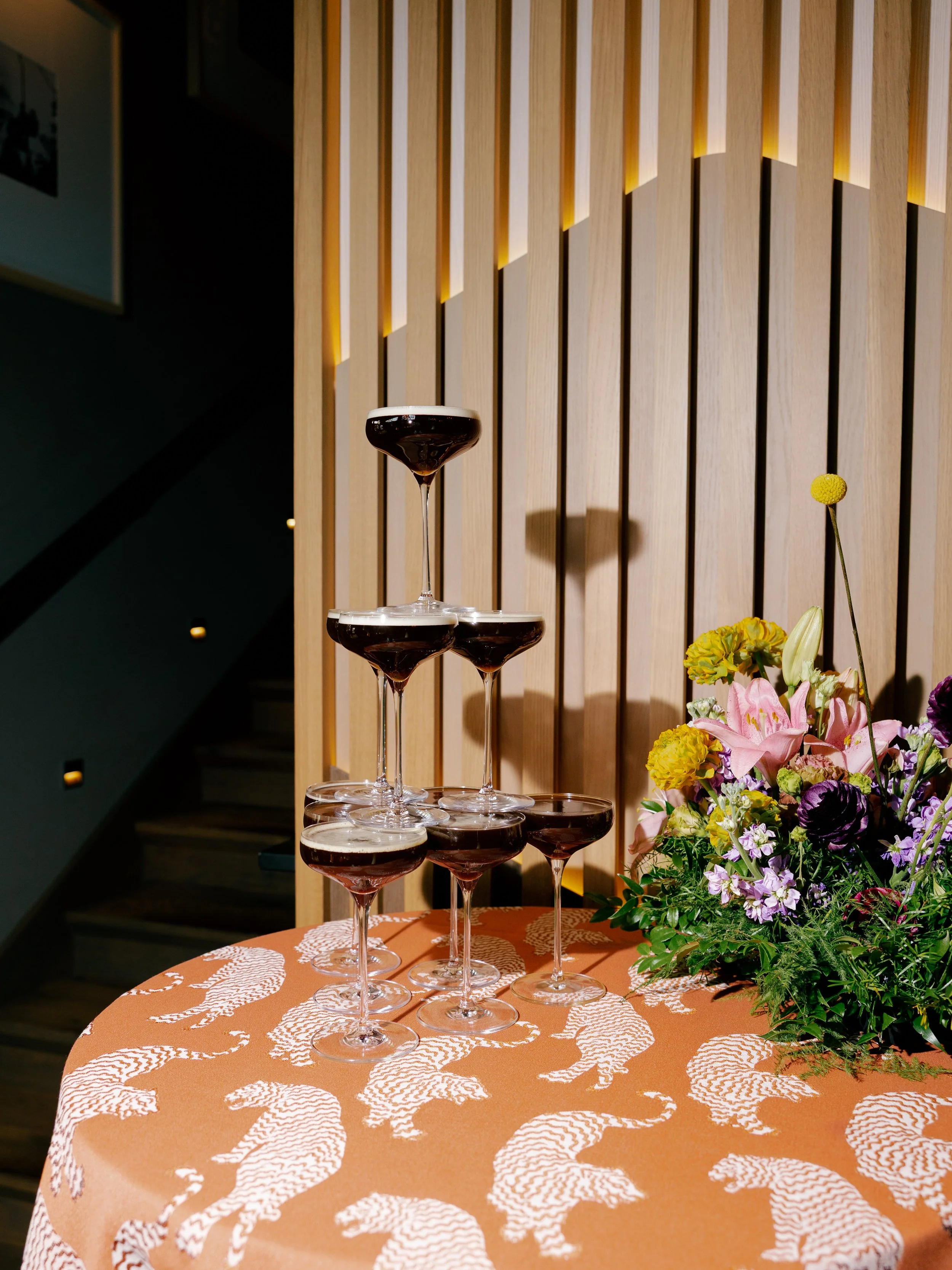 espresso-martini-tower-on-orange-print-tablecloth-with-wildflower-floral-pieces.jpg