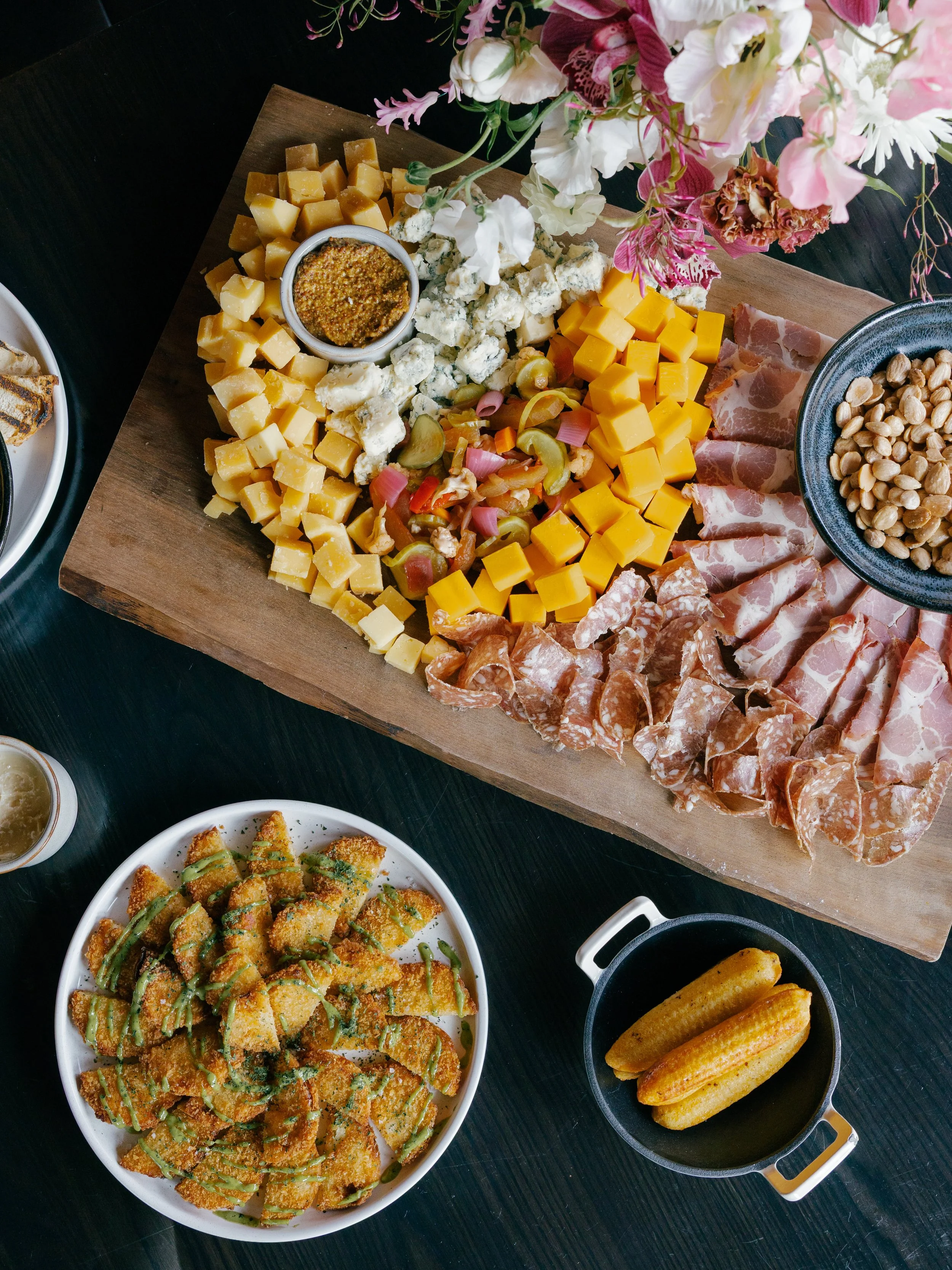 overflowing-charcutterie-board-on-aethetic-wood-and-black-table-setting.jpg