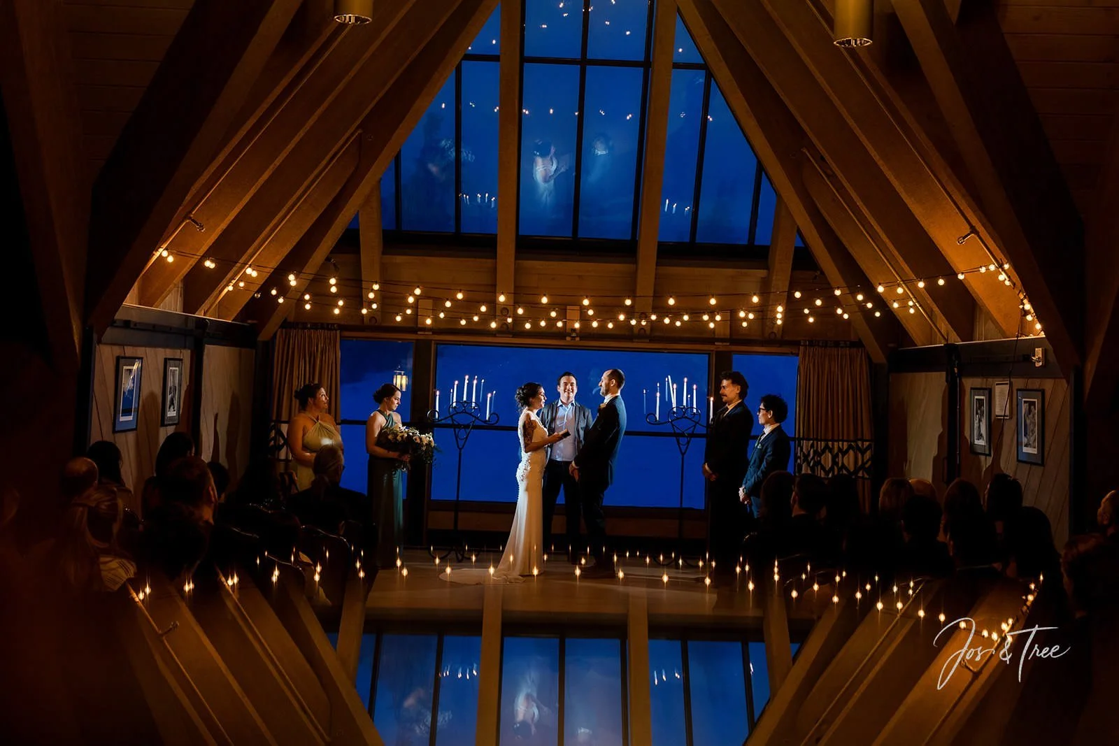 bridal-party-and-couple-in-during-ceremony-in-front-of-a-frame-windows.jpg