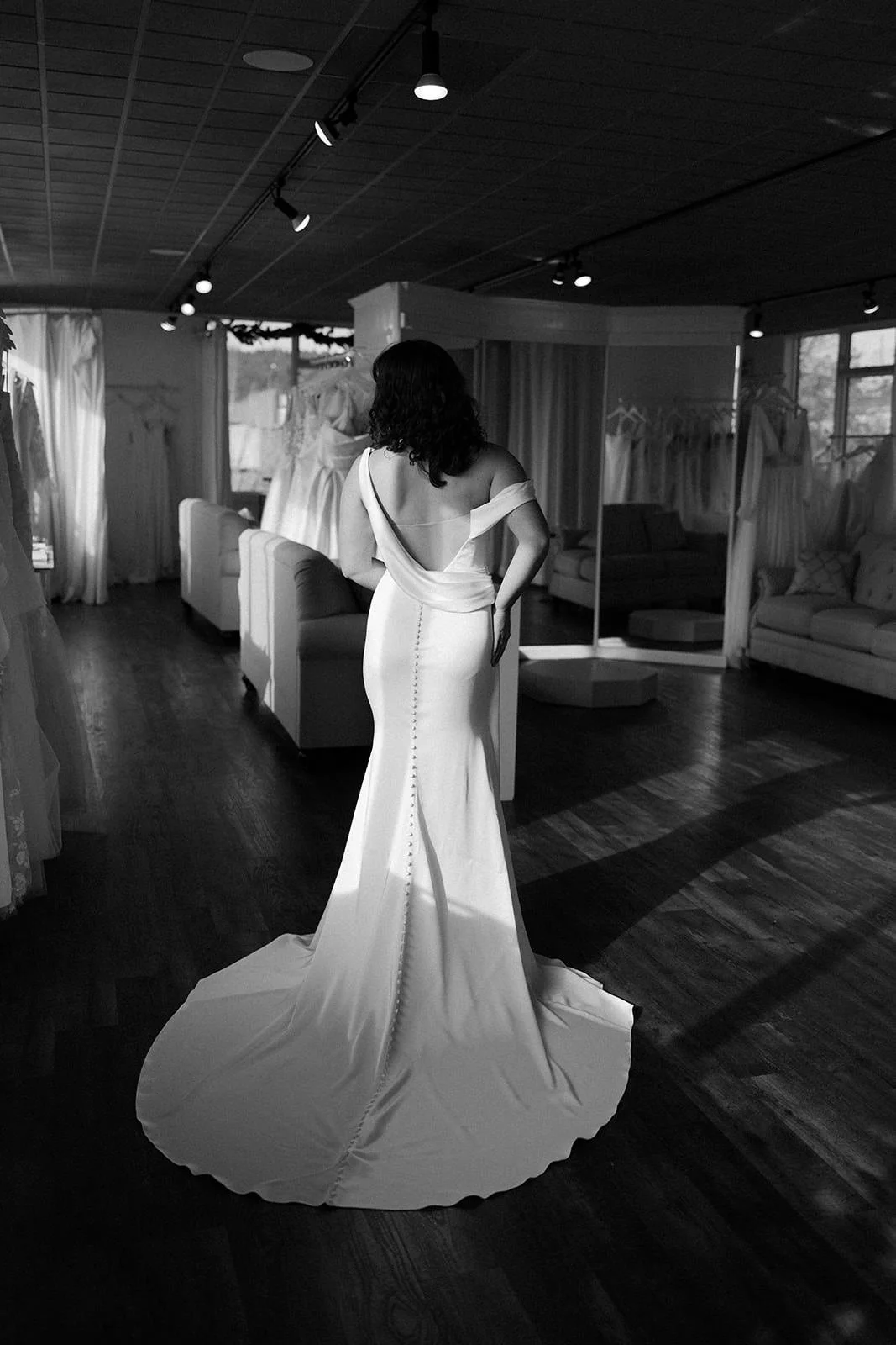 photo of back of bride wearing open back one shoulder satin wedding dress