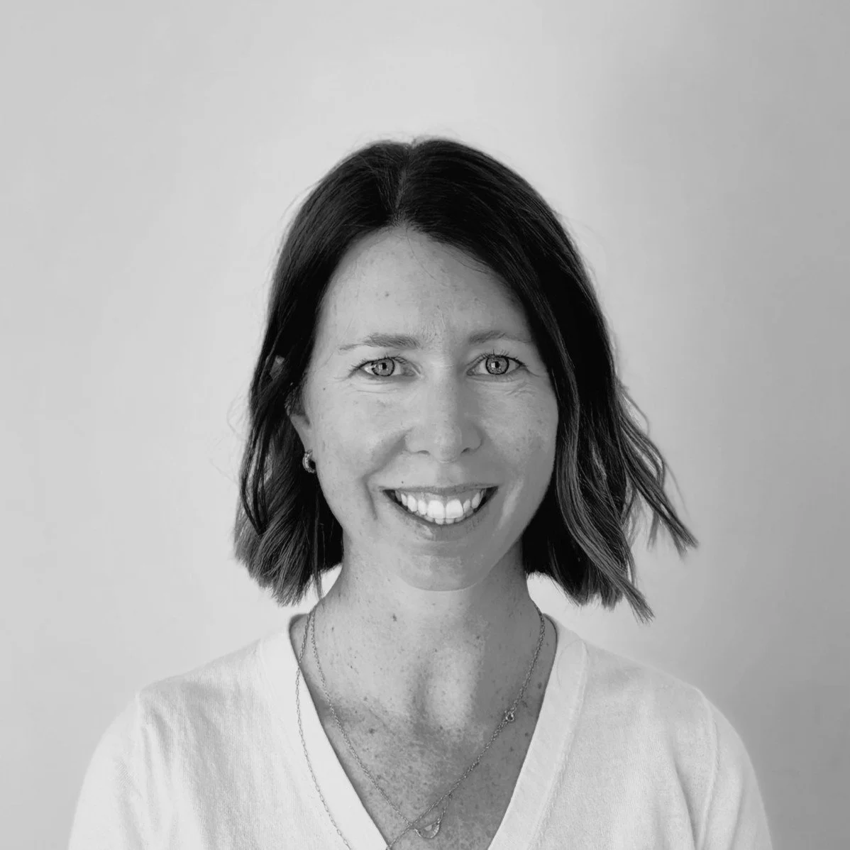 Black and white portrait of a person wearing a patterned button-up shirt.
