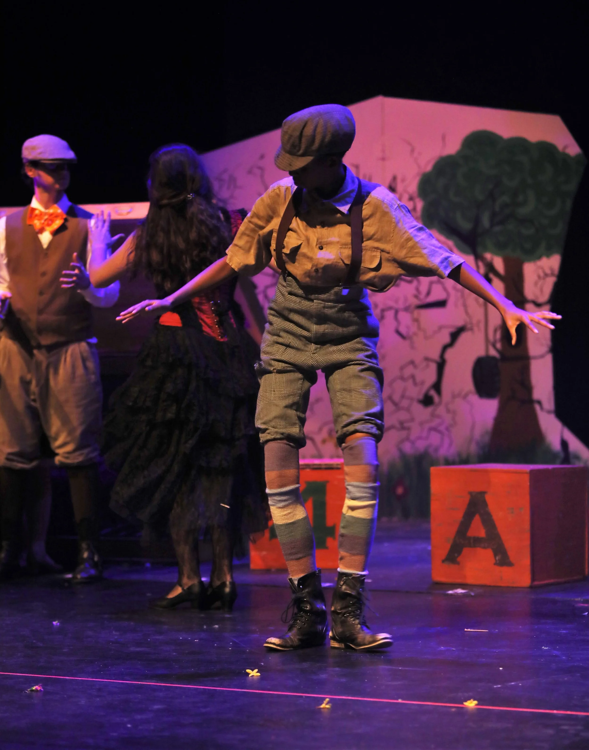 Button up shirt paired with suspenders as to implement a more child like appearance; paired with green knickers, colorful striped leg warmers and worn-out boots