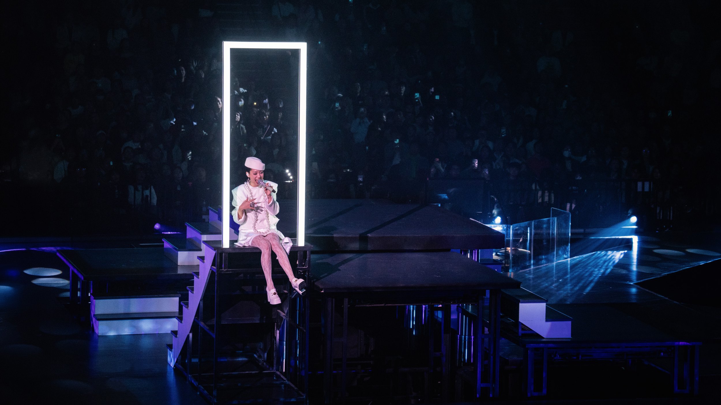 Jace Chan seated within glowing light frame structure during Jace World performance, modular pop concert stage design by London set designer Ruby Law.