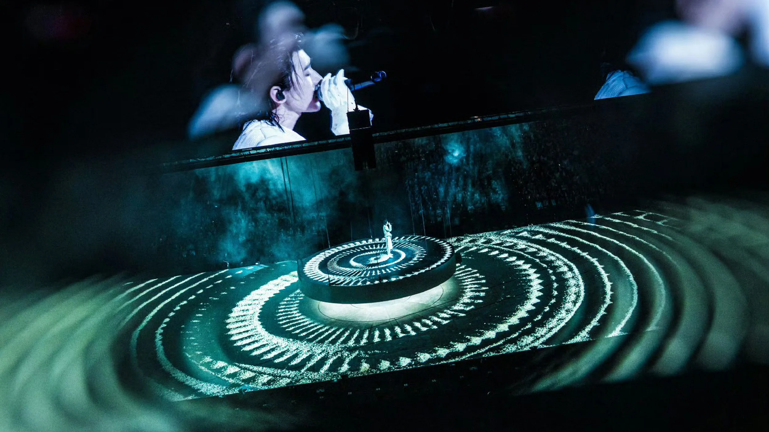 KUN 蔡徐坤 performing on a suspended circular stage with concentric floor projections, designed by set designer Ruby Law, RULA 舞美設計.