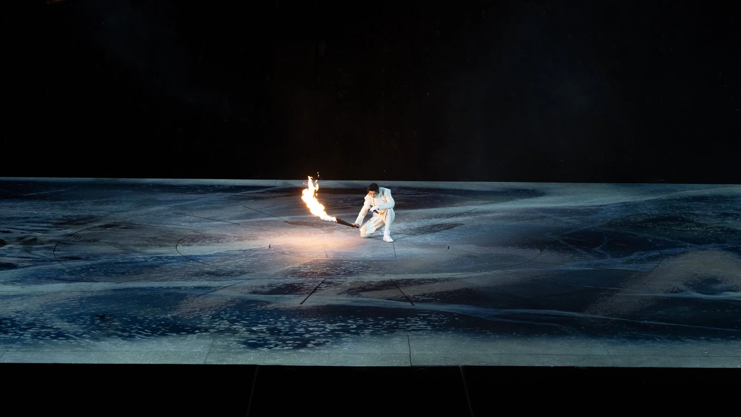 KUN 蔡徐坤 performing with a flaming torch across an immersive projected landscape, Deadman stage design by Ruby Law, RULA 舞美設計師.