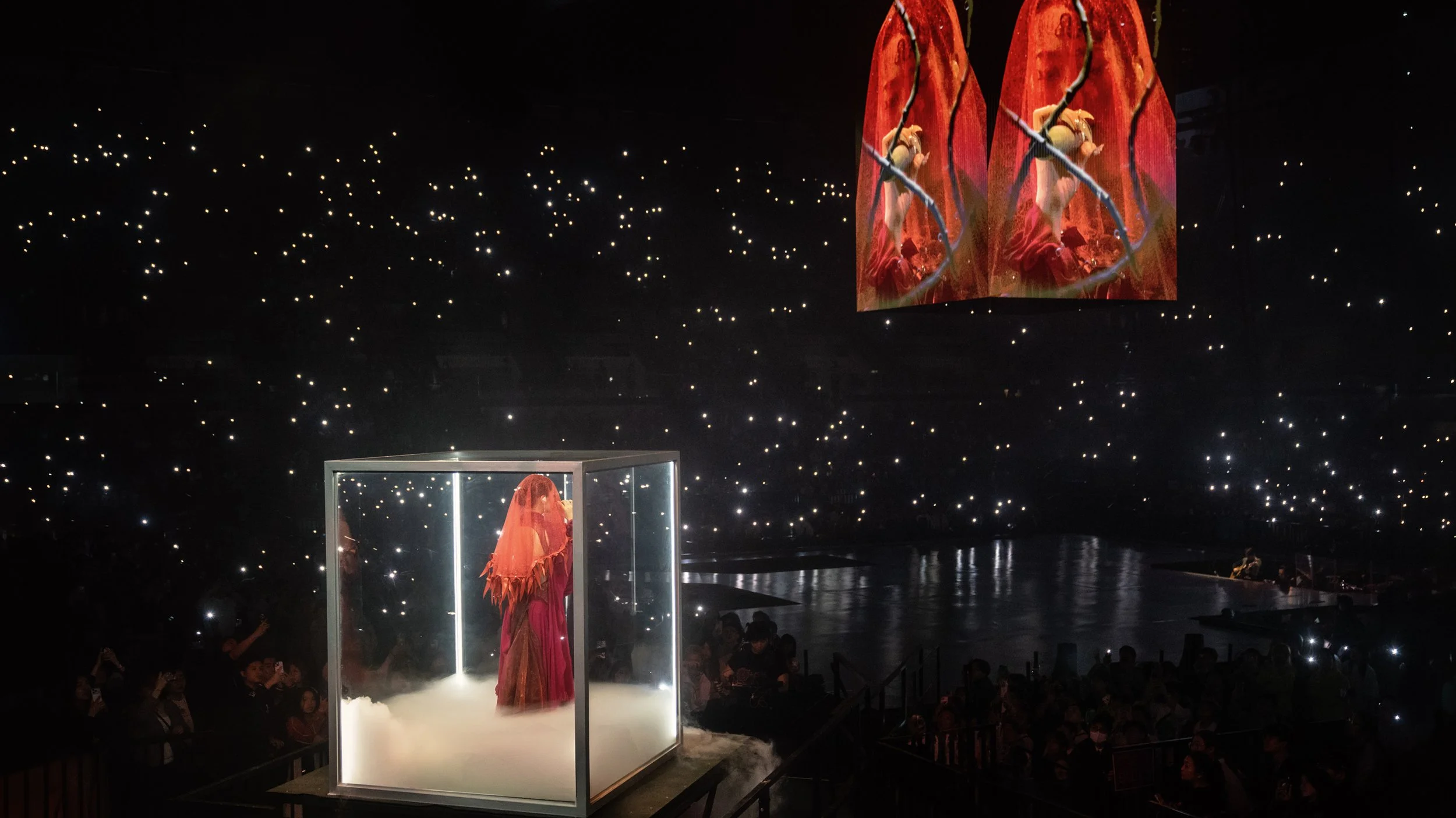 Jace Chan enclosed in illuminated cube installation surrounded by audience lights in Jace World, immersive pop concert stage design by London set designer Ruby Law.