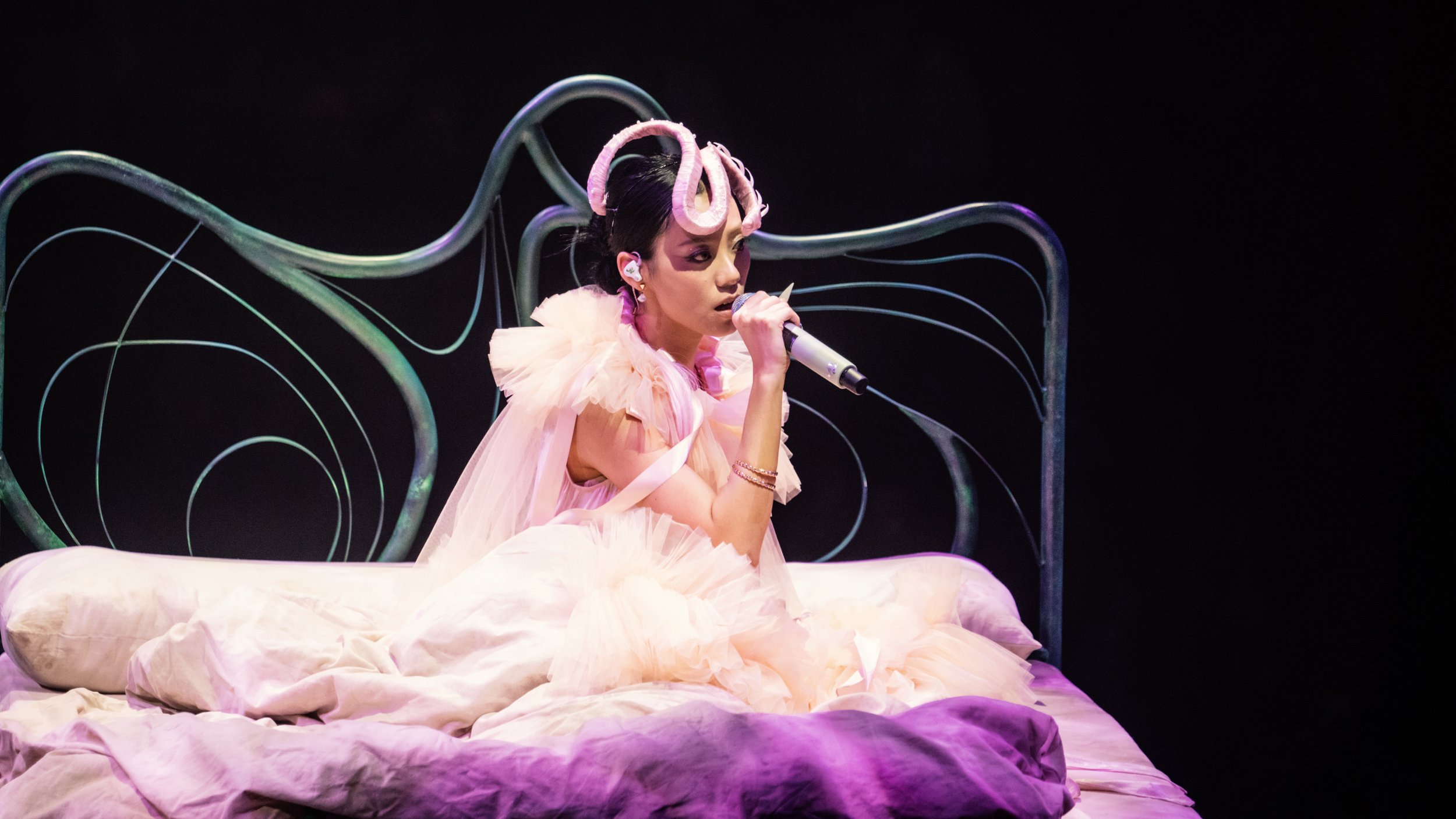 Close view of Jace Chan singing on art nouveau bed set piece in Jace World, pop music set designer Ruby Law based in London.