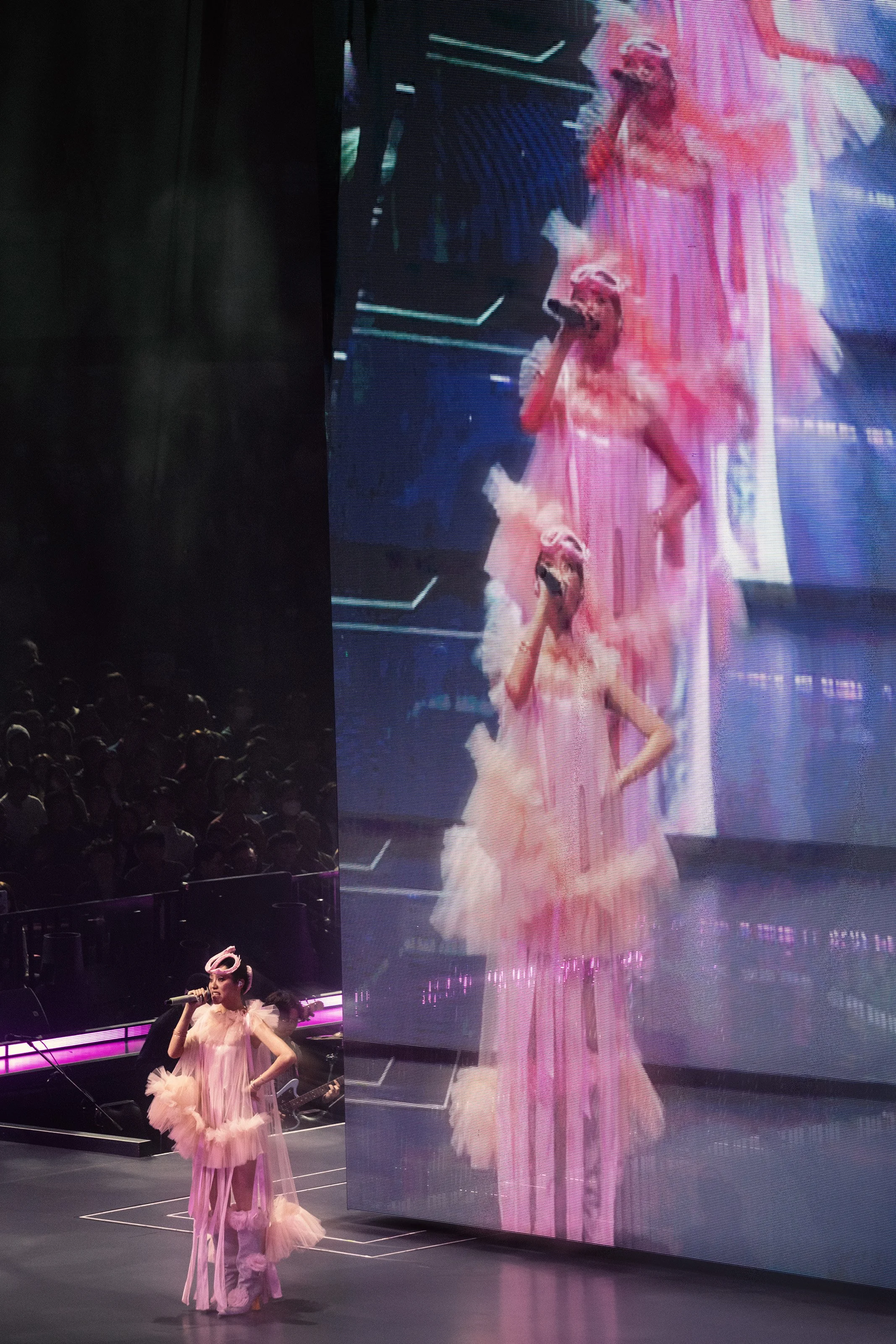 Jace Chan singing in front of live feed multiplication image in Jace World arena show, pop concert stage design by London set designer Ruby Law.