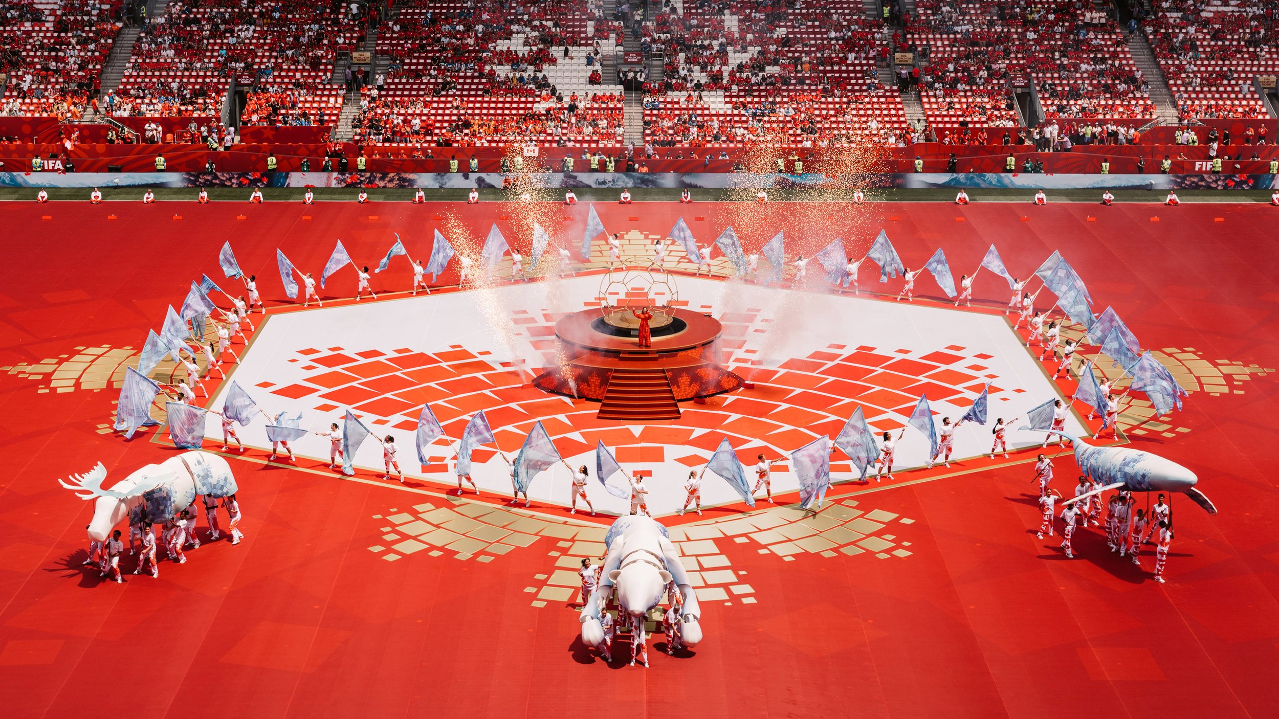 Mosaic-inspired polar bear, moose and humpback whale puppets crossing the field during the FIFA World Cup 2026 Toronto Opening Ceremony, designed by Ruby Law from RULA design studio