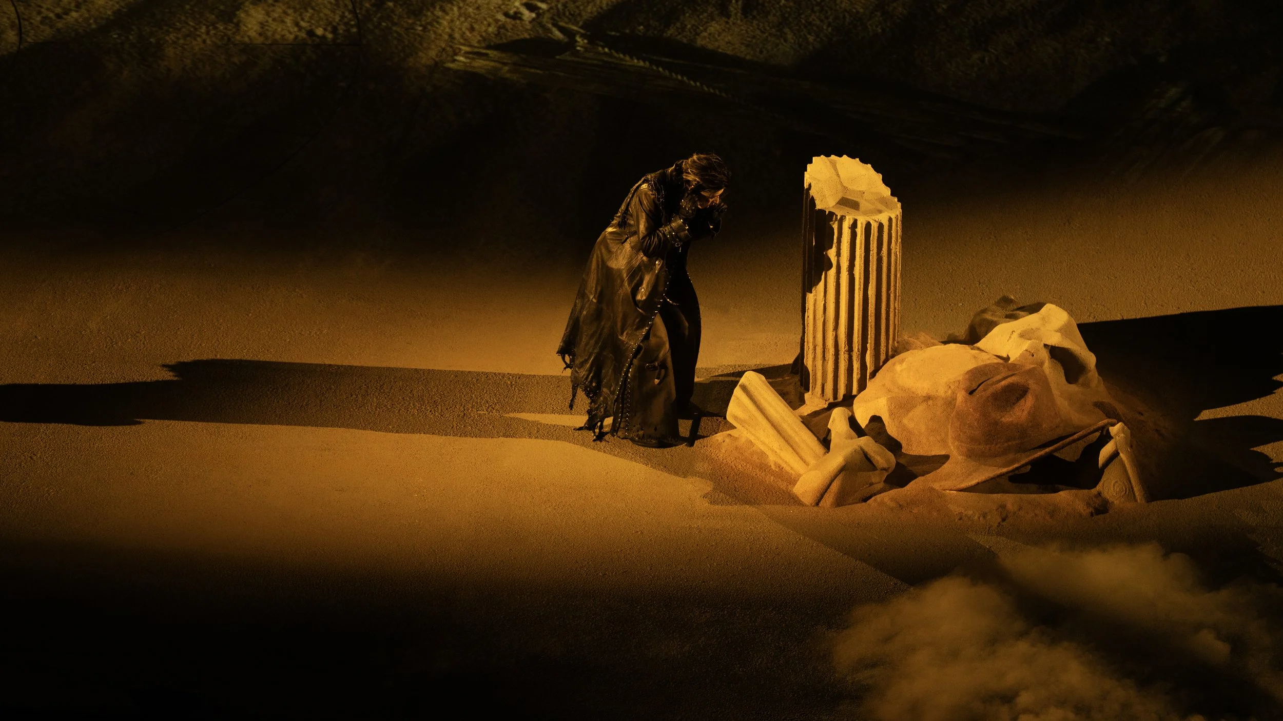 KUN 蔡徐坤 DEADMAN surrounded by half-buried classical ruins in a sand landscape, set designer Ruby Law, RULA