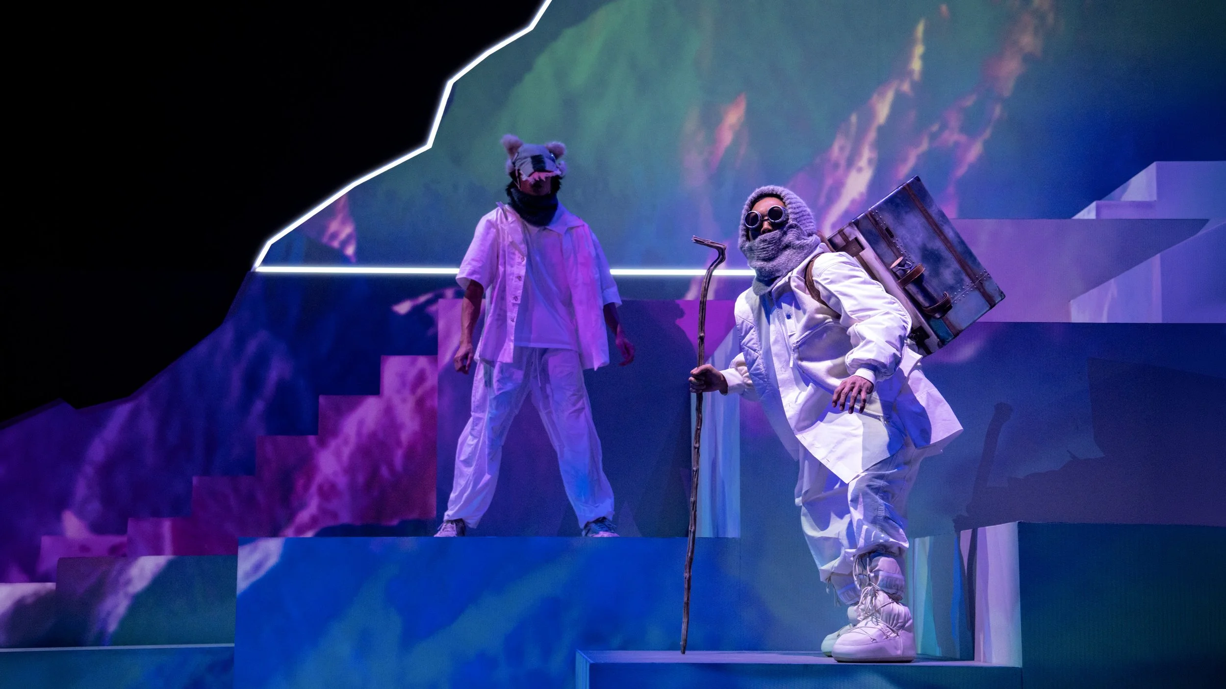 Performer with expedition costume on geometric mountain stage, immersive set design by Ruby Law RULA London