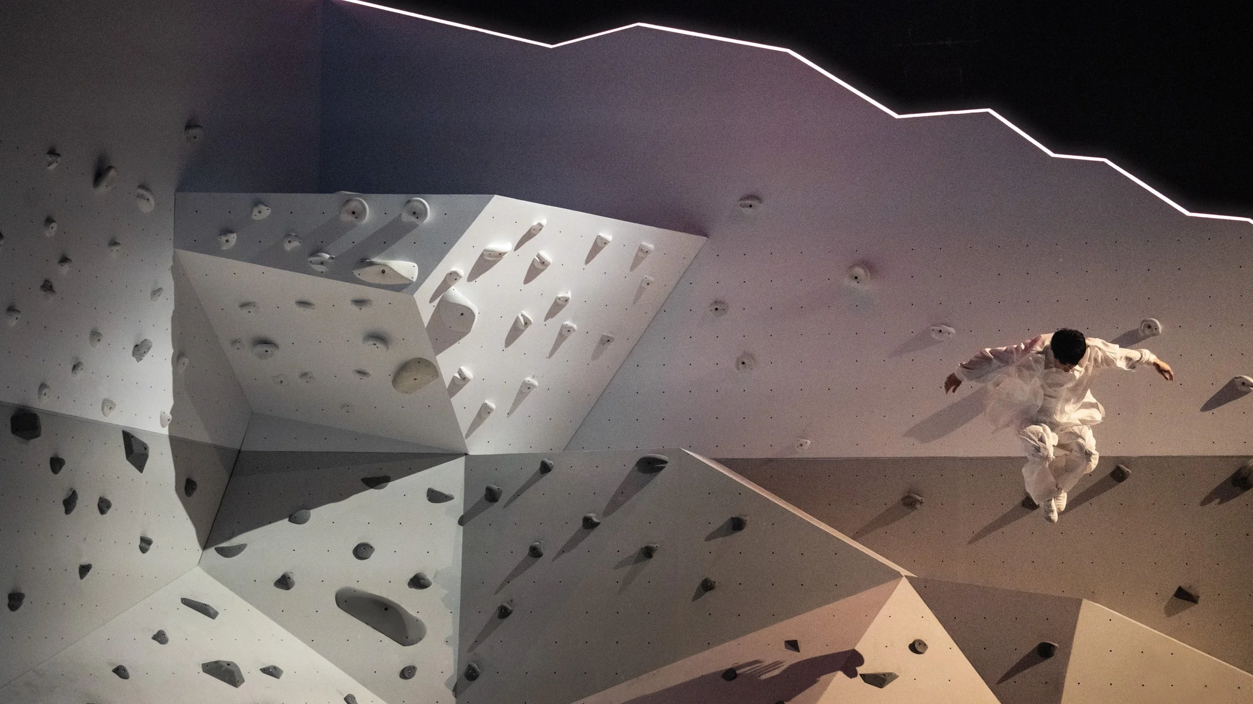 Dancer interacting with faceted mountain set and horizon light, contemporary set design by Ruby Law RULA