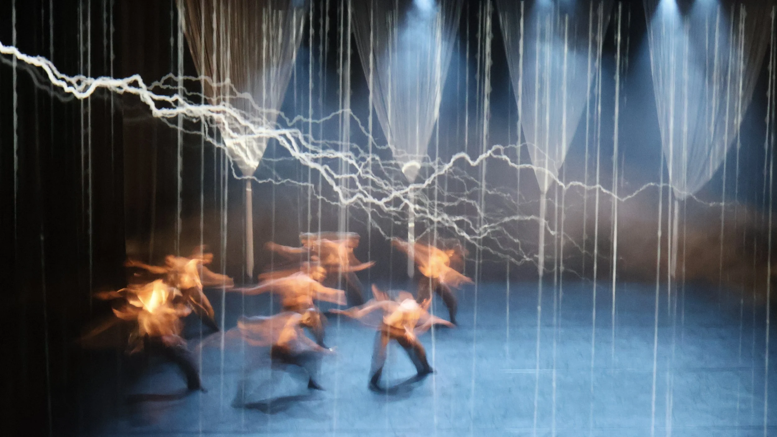 Ensemble standing beneath projected white tree canopy emerging from string curtain structure in Tellus by Dickson Mbi, contemporary dance set design by London set designer Ruby Law.
