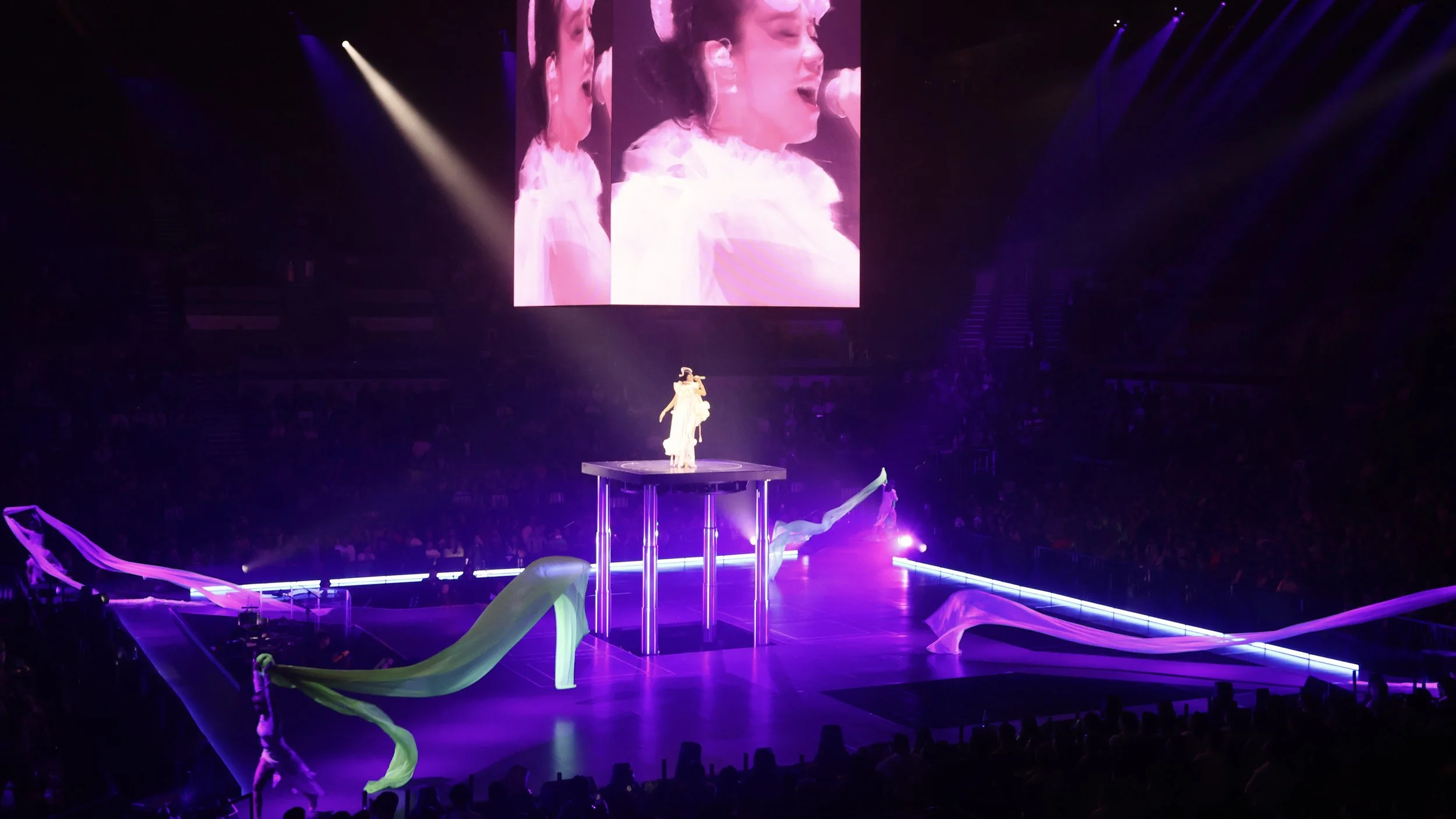 Jace Chan performing on elevated platform with flowing fabric elements representing shifting horizons in Jace World, stage design by London set designer Ruby Law.
