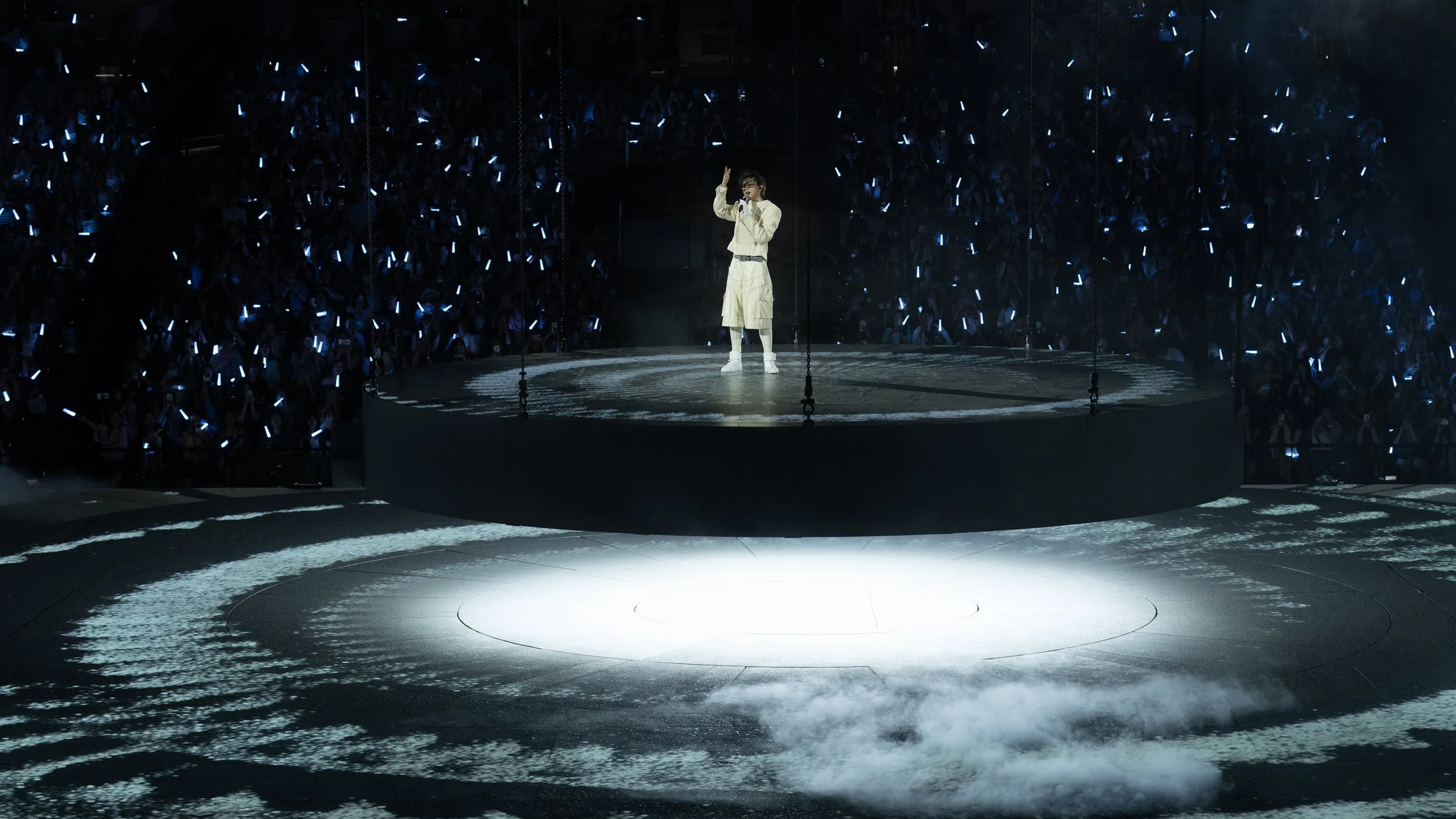 KUN 蔡徐坤 performing on an elevated circular stage surrounded by the arena audience, Deadman concert set design by Ruby Law 舞美設計師.