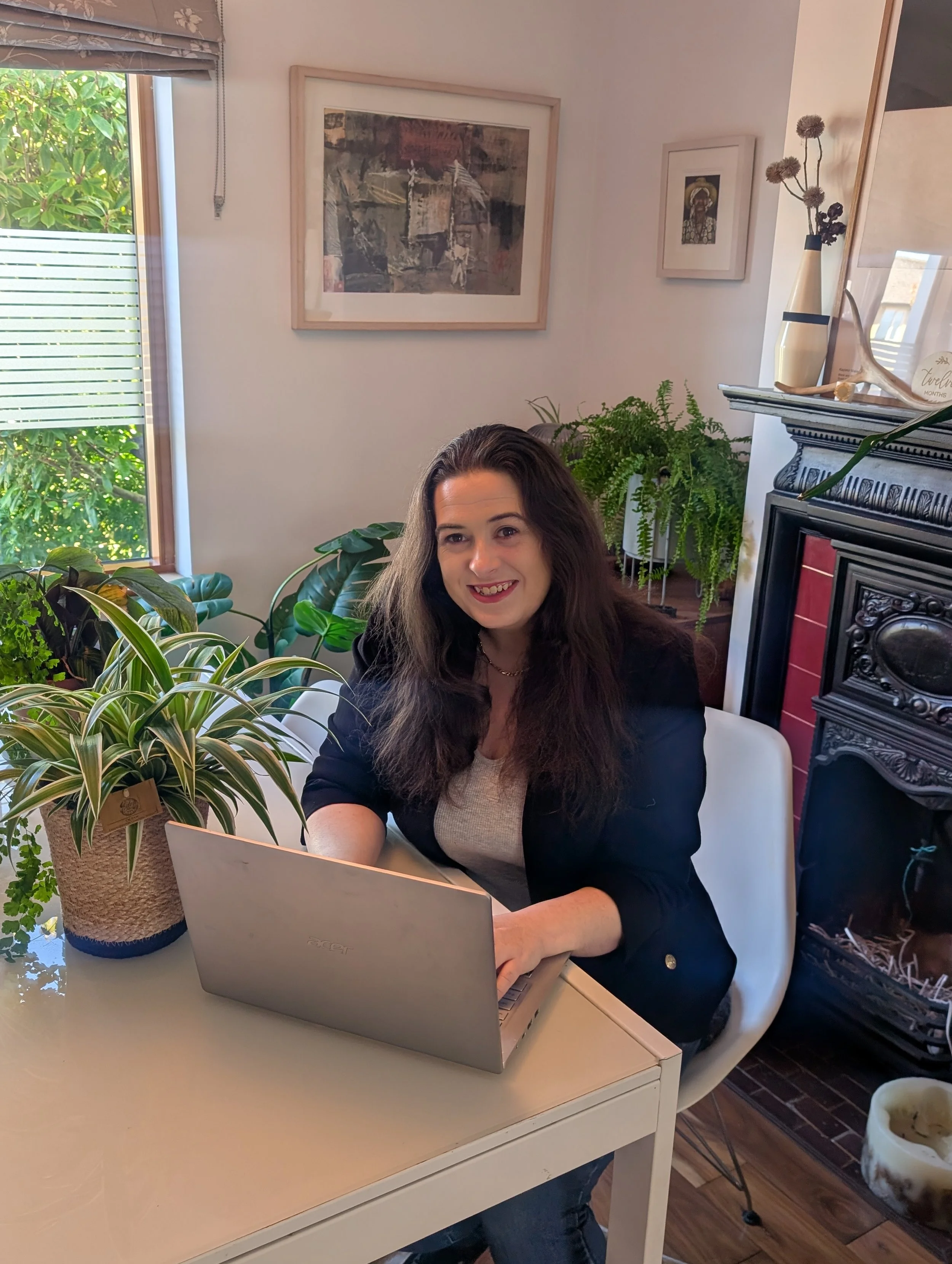 Photograph of website designer Sarah Brennnan sitting at a desk with a laptop