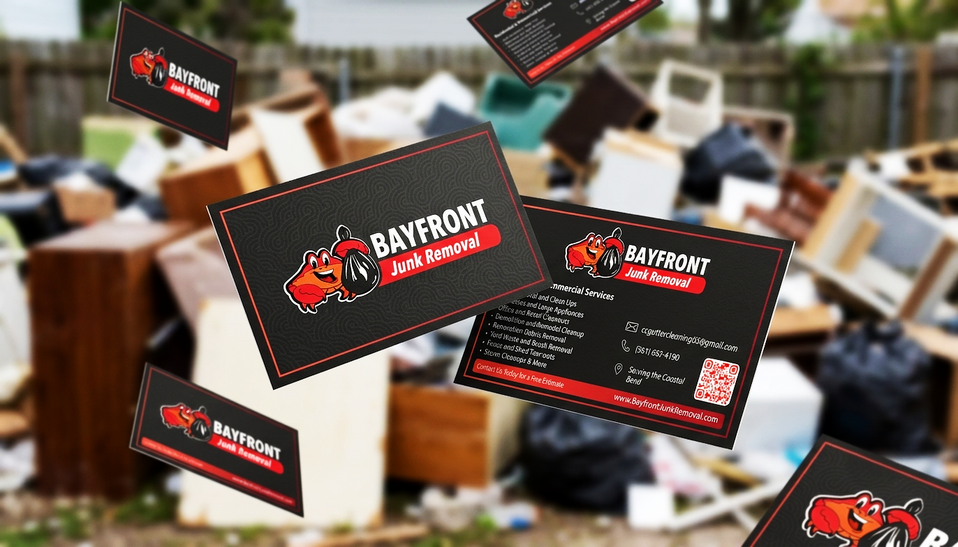 Business cards for Bayfront Junk Removal floating in front of a pile of trash and discarded furniture.