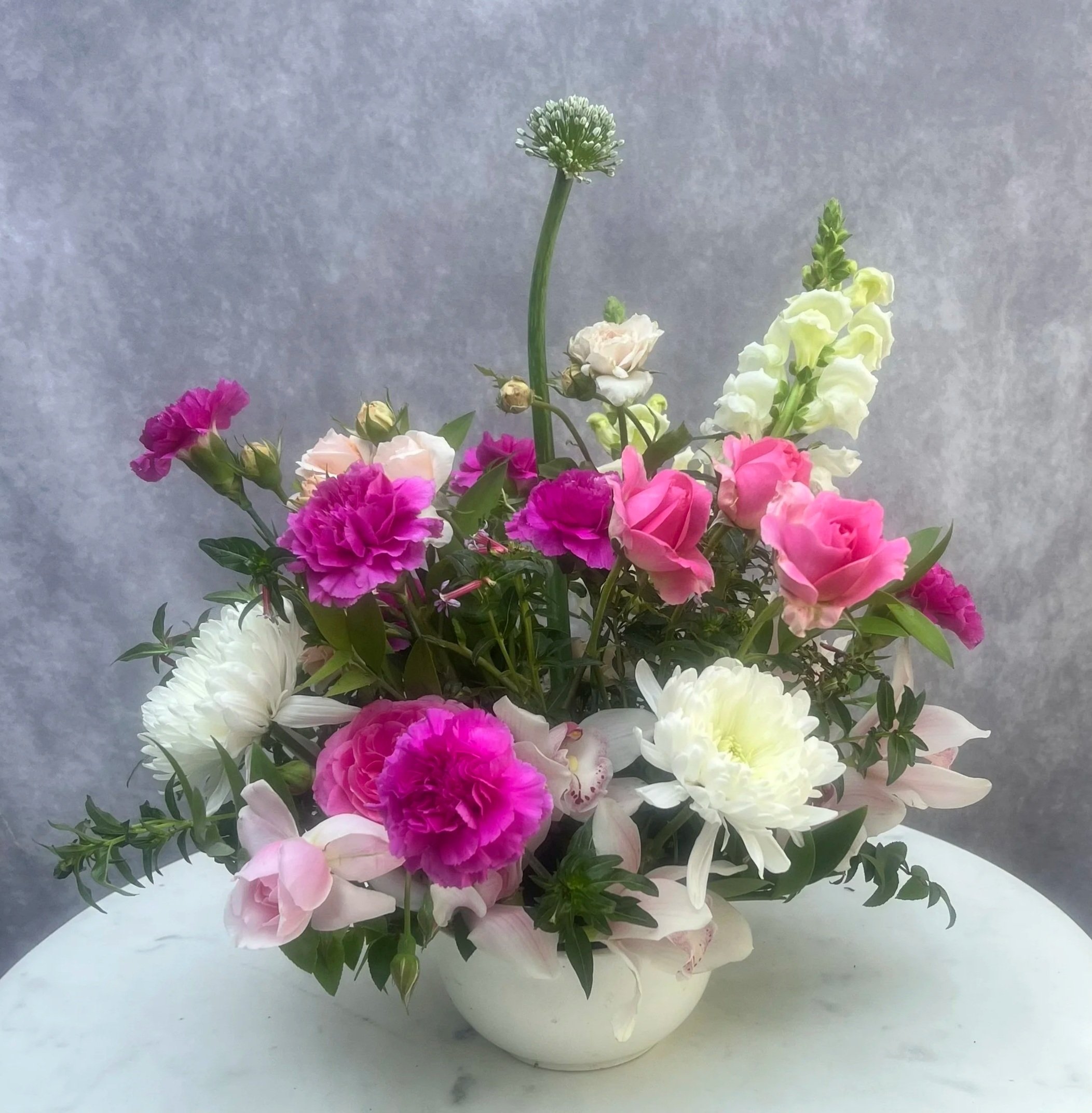 Bright pink and white garden-style floral arrangement in a high-end vase with seasonal blooms and greenery, designed for birthdays and special occasions.