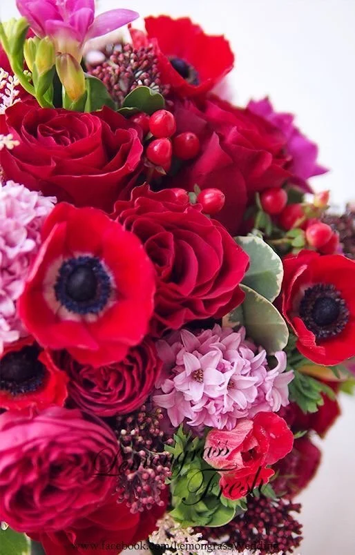 Close-up of red, burgundy, and pink Valentine’s Day flowers arranged in a romantic, lush floral design.