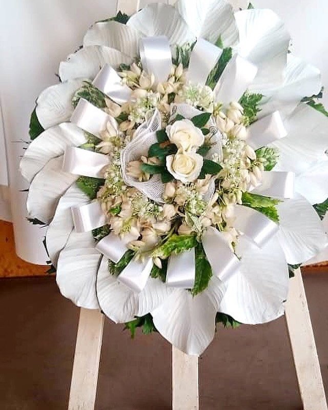 Remember a loved one with this remembrance wreath. A touching way to pay tribute to someone who has passed. Wreaths are the appropriate choice of funeral flower arrangements to send to a church service or burial site. For more information, call, DM o
