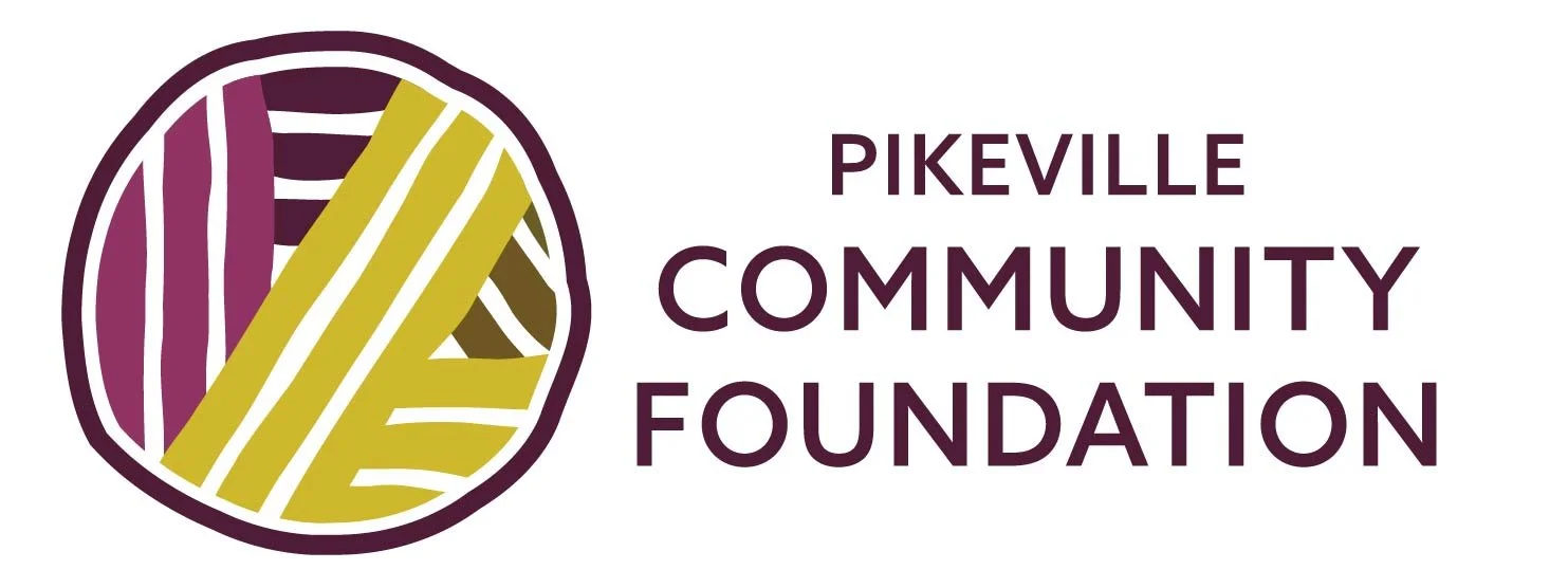 Logo of the Pikeville Community Foundation featuring a circular design with abstract lines in purple, yellow, and black, accompanied by the text 'Pikeville Community Foundation' in purple.