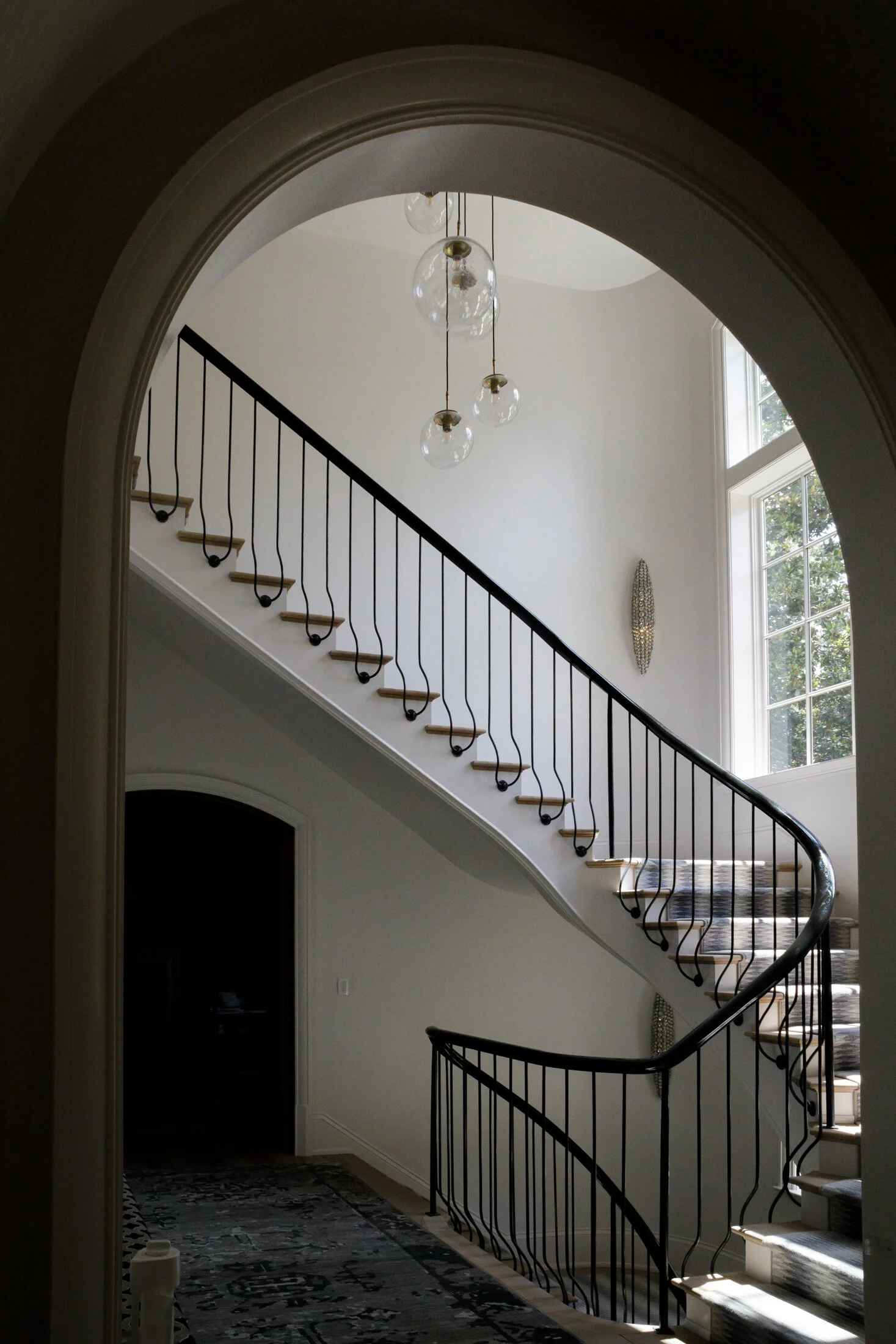 image looking into an interior space through an arched entrance of a railing fabricated by smithworks iron and design