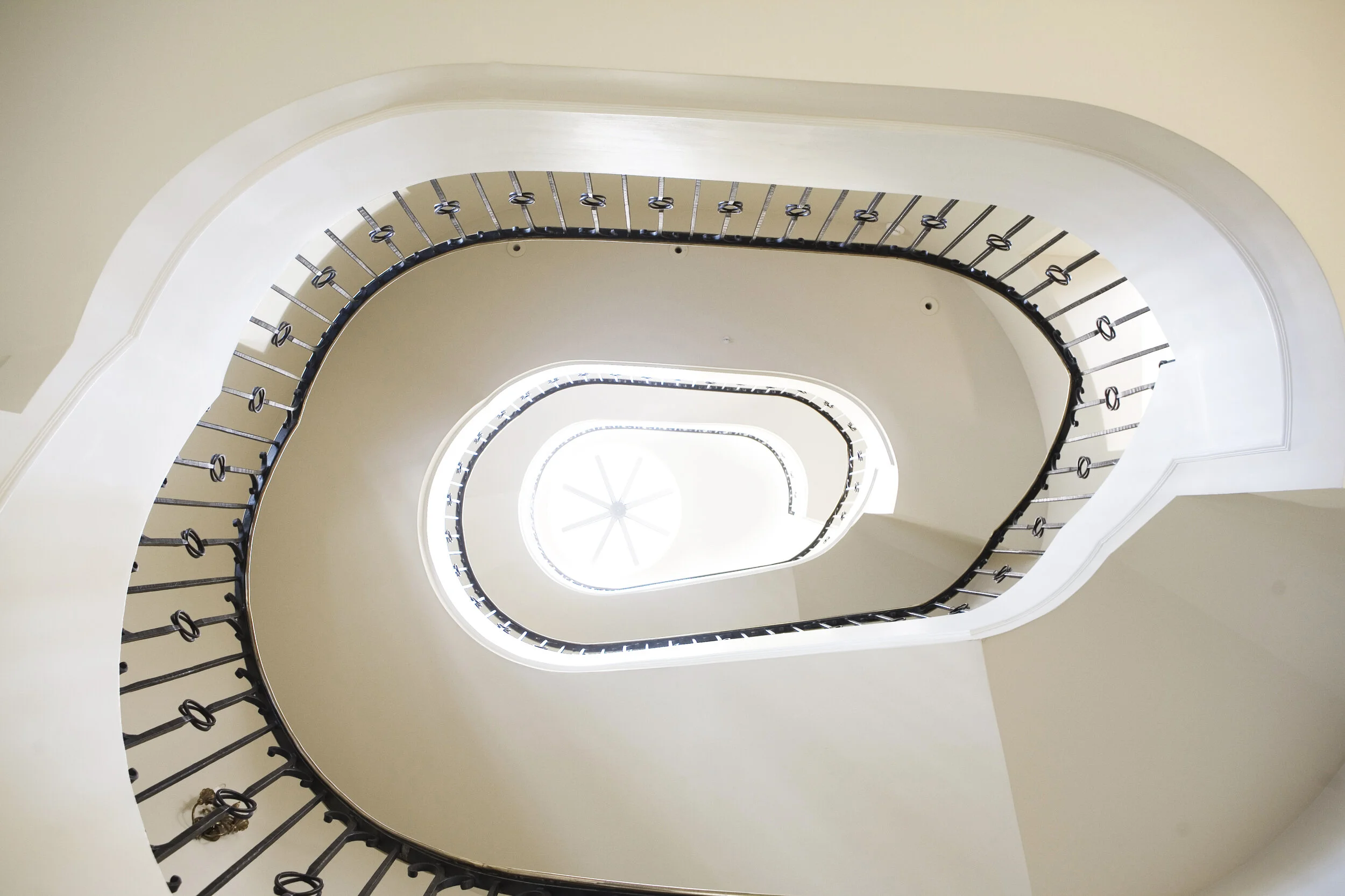 image looking up of a spiraling stair case featuring ornamental iron work by smithworks iron and design