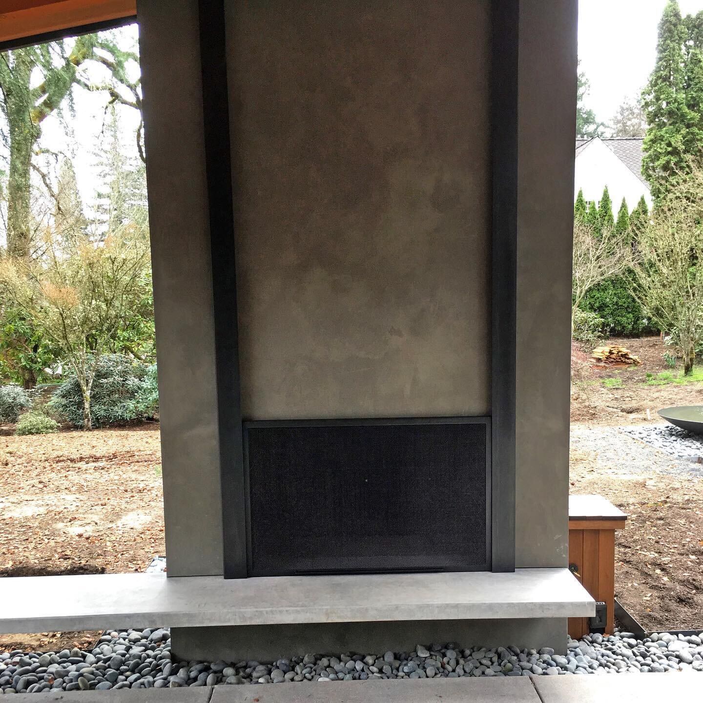 Counter-weighted guillotine fire screen in an outdoor seating area. #custommetalfabrication #outdoorfireplace #portland