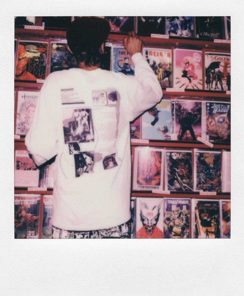 Person browsing comic books on store shelves.