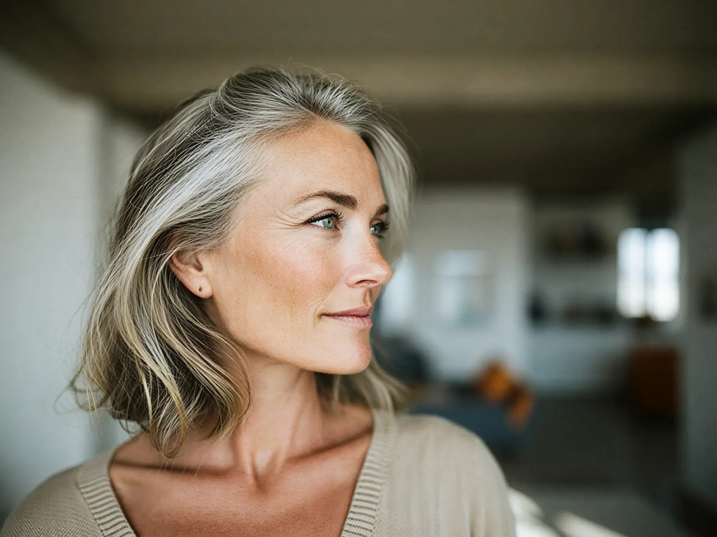 A woman with gray hair looking off to the side with a slight smile.