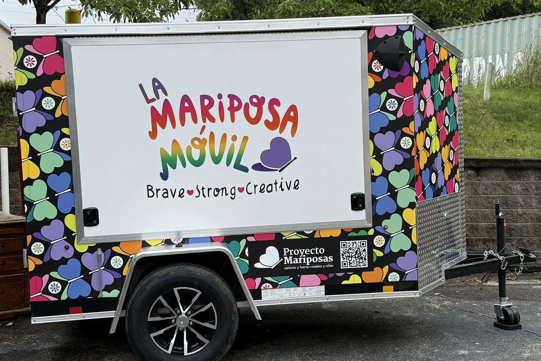 Photo of a brightly colored trailer covered in butterfly illustrations