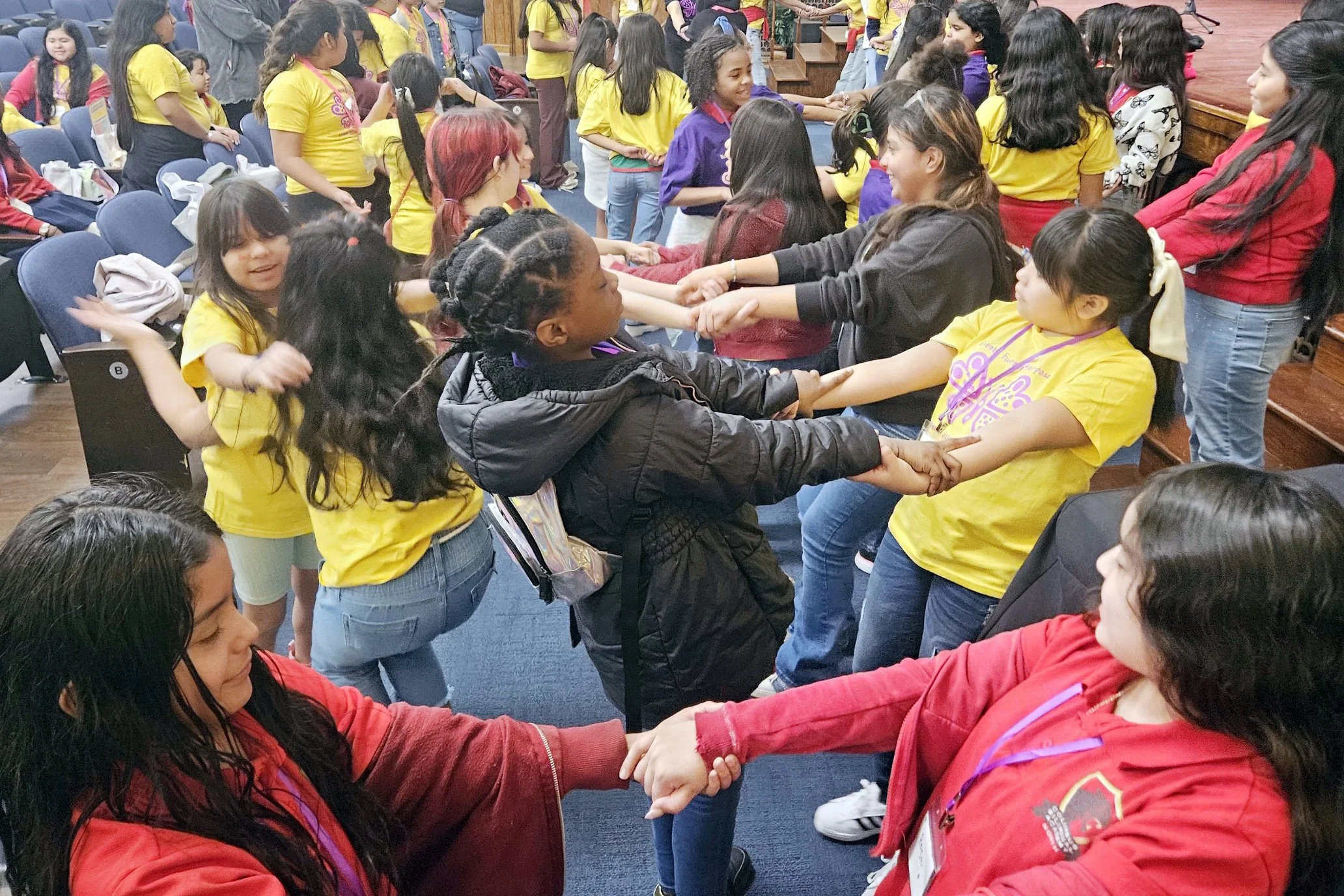 Group of Latina girls holding hands and working together
