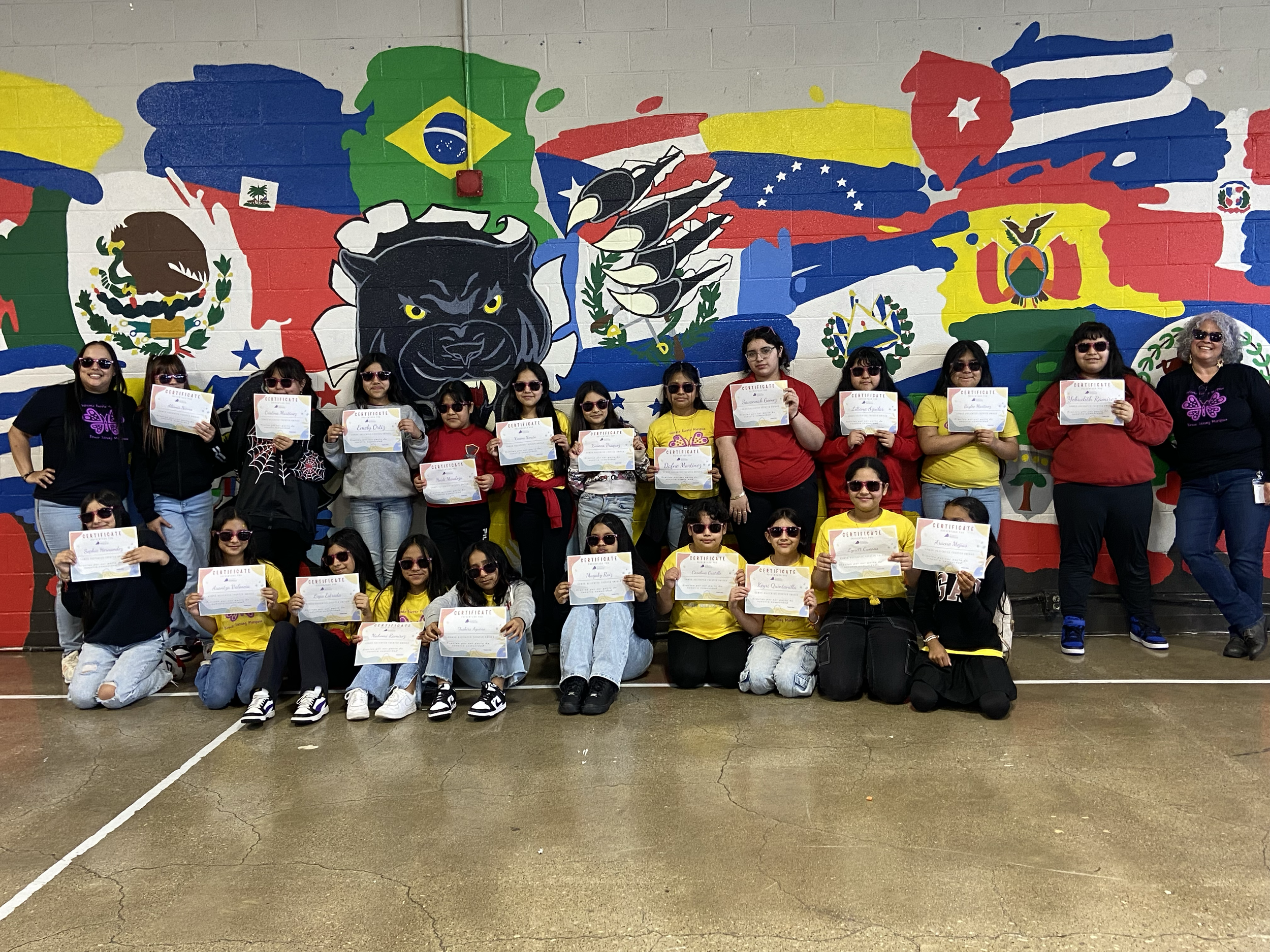 Large group of Latina girls holding certificates of completion