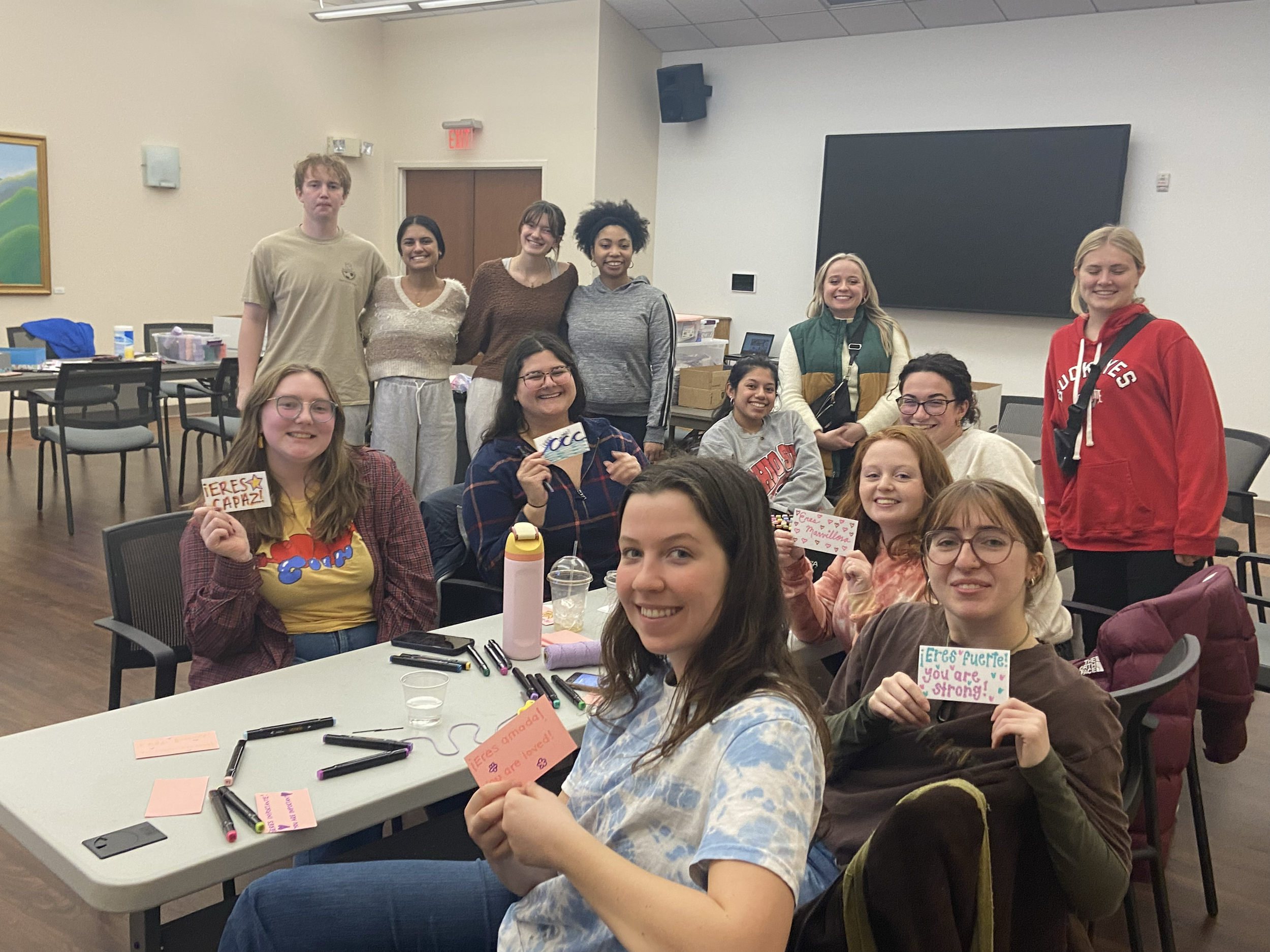 Group of volunteers sitting around a table packing period kit supplies