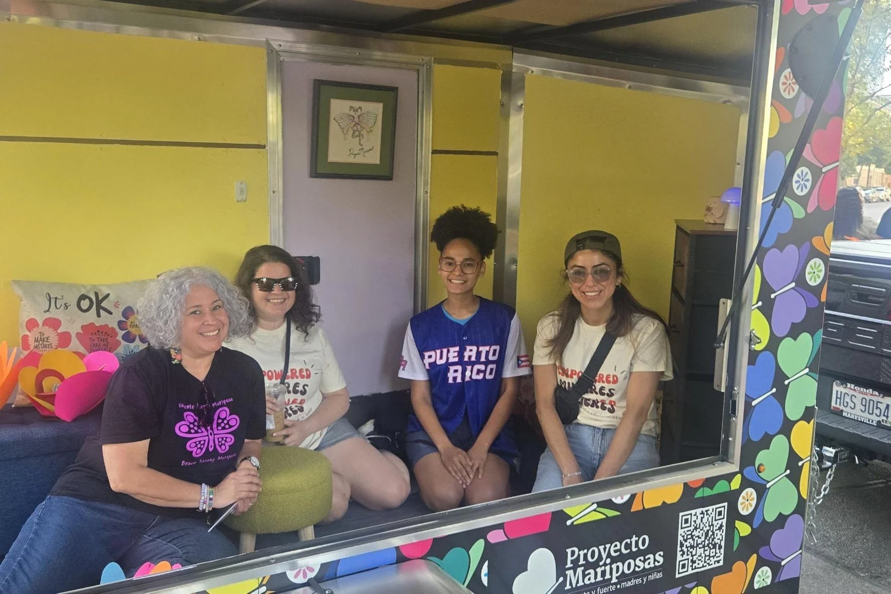 Group of young latinas sitting in the art mobile