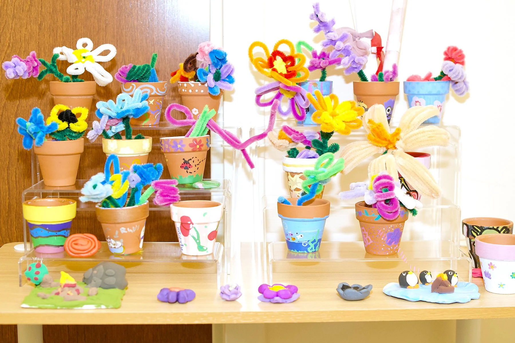 Shelf displaying handmade pipe cleaner flowers