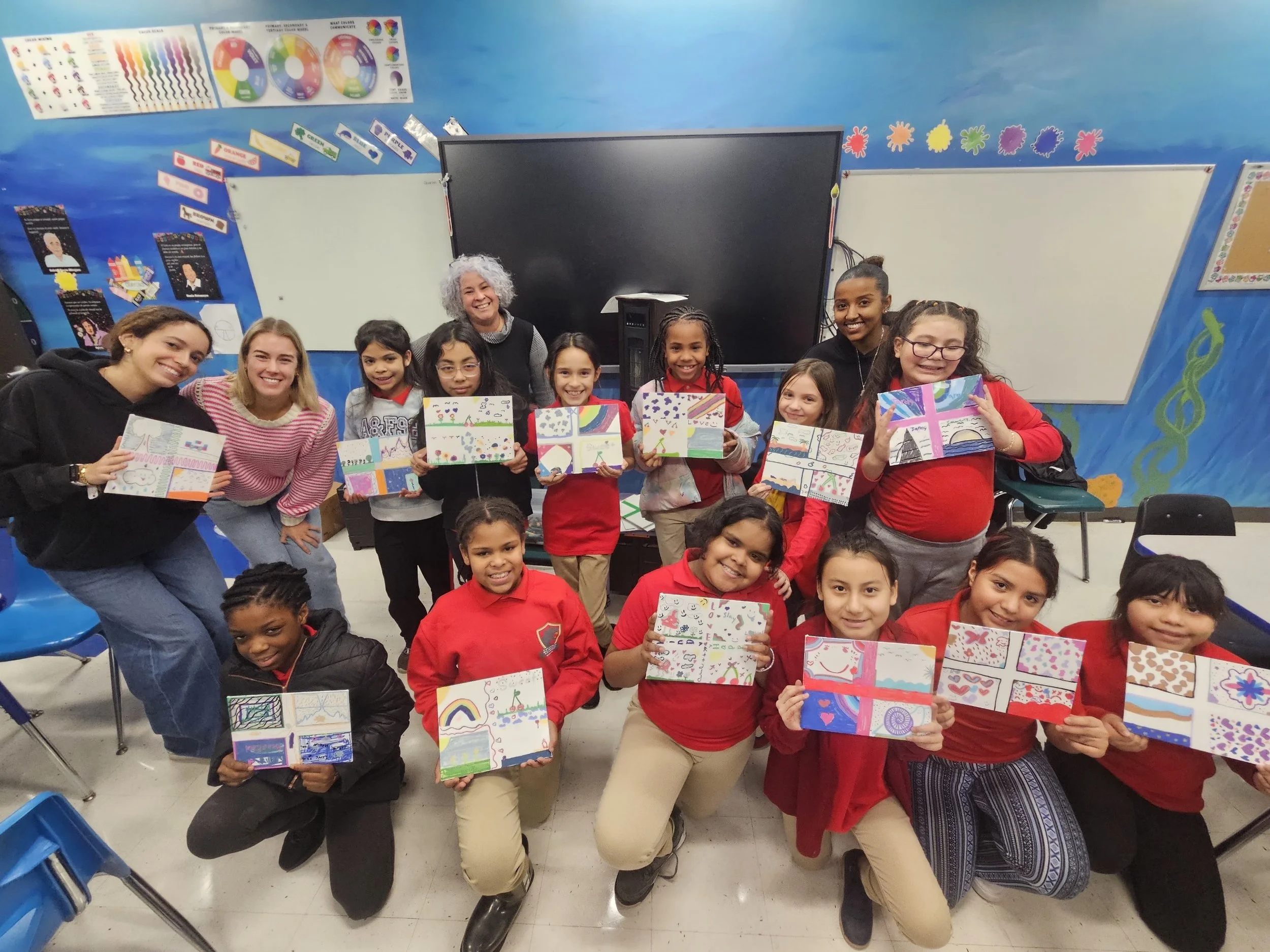 Group of Latina school girls holding small canvases of uplifting artwork